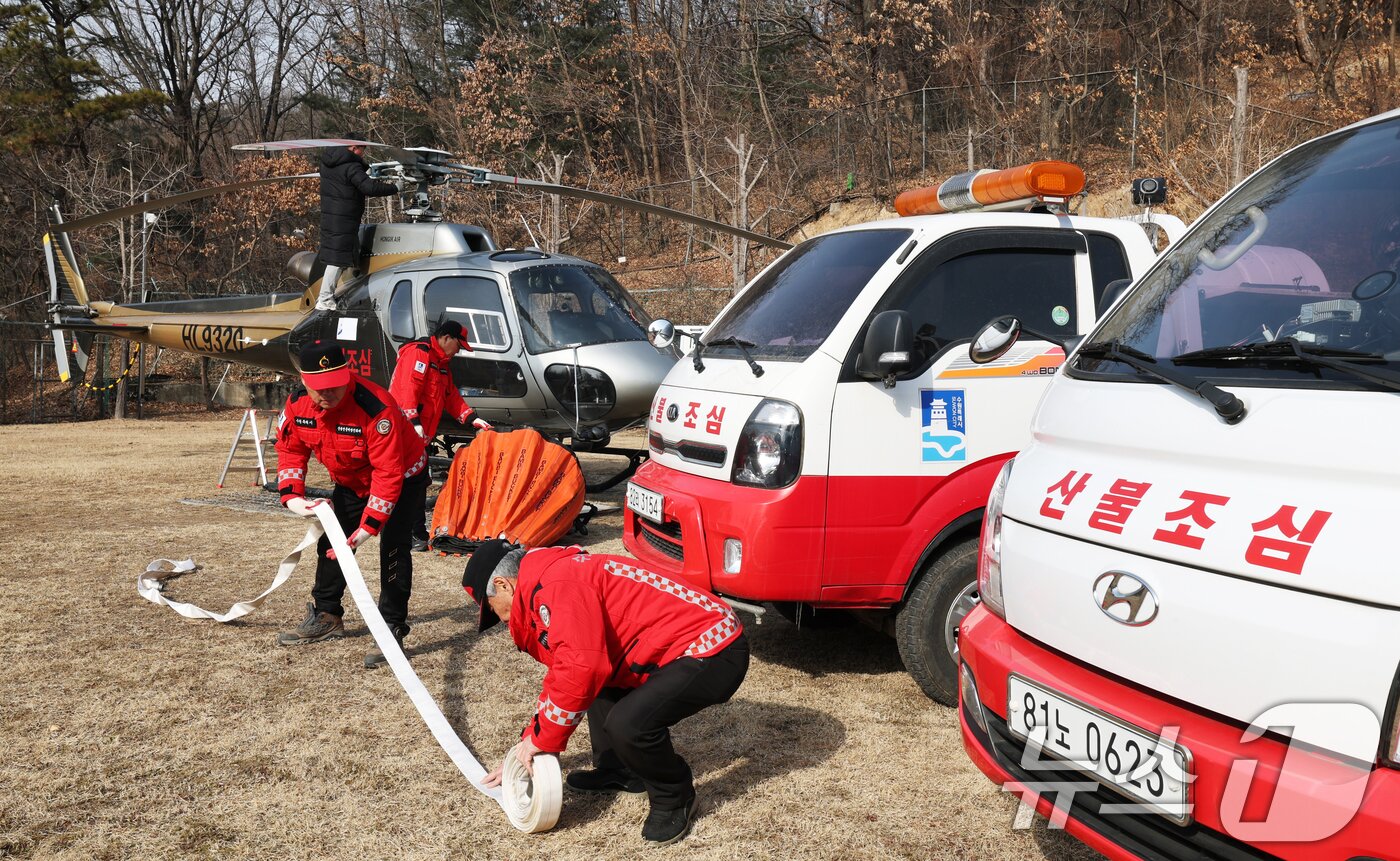 본문 이미지 - 지난달 26일 경기 수원시 장안구 산불진화헬기 임시계류장에서 수원시 산불감시원과 헬기 정비사가 다목적 산불진화차량 및 산불 대응 헬기를 점검하고 있다. 앞서 산림청은 산불위기경보를 '주의'로 상향하고 전국에 산불 경계령을 내렸다. 2026.1.26 ⓒ 뉴스1 김영운 기자