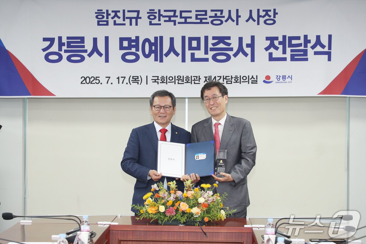 본문 이미지 - 지난해 7월 정동진 IC 및 TG 신설 업무협약식에서 함진규 한국도로공사 사장(사진 오른쪽)에게 명예시민증서를 수여하는 김홍규 강릉시장.(강릉시 제공, 재판매 및 DB 금지)