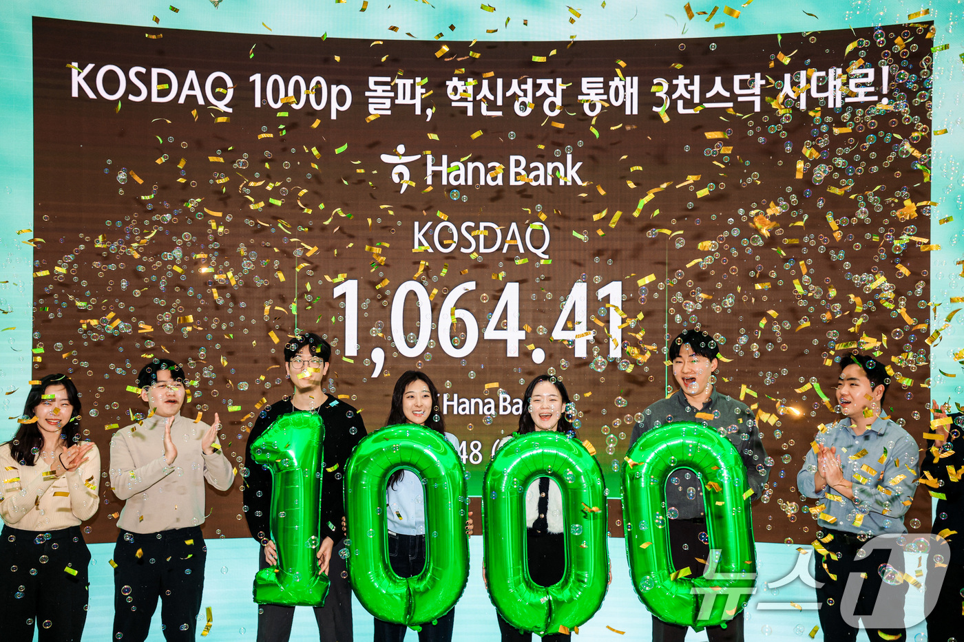 (서울=뉴스1) 안은나 기자 = 코스닥지수가 1000을 돌파해 1,064.41 포인트로 마감한 26일 서울 중구 하나은행 본점에서 직원들이 축하세리머니를 하고 있다. (공동취재) …
