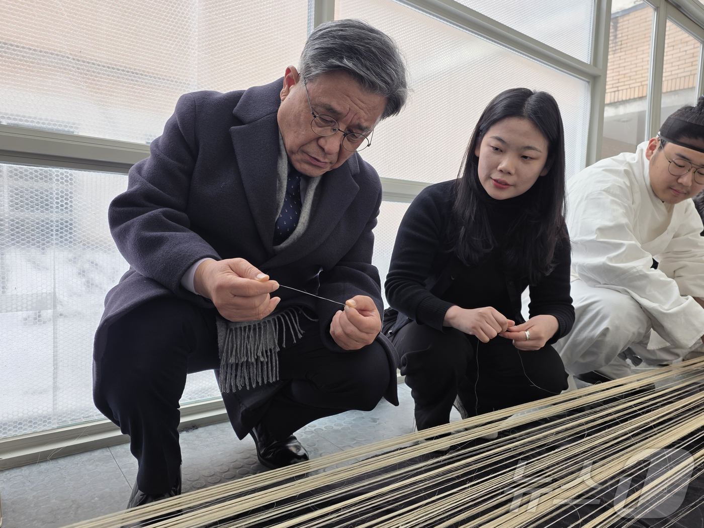 (서울=뉴스1) = 허민 국가유산청장이 26일 오후 충남 부여군 소재 한국전통문화대학교 실습동을 방문해 전수교육학교 출신 이수자 씨에게 한산모시짜기 과정에 대한 설명을 듣고 있다. …