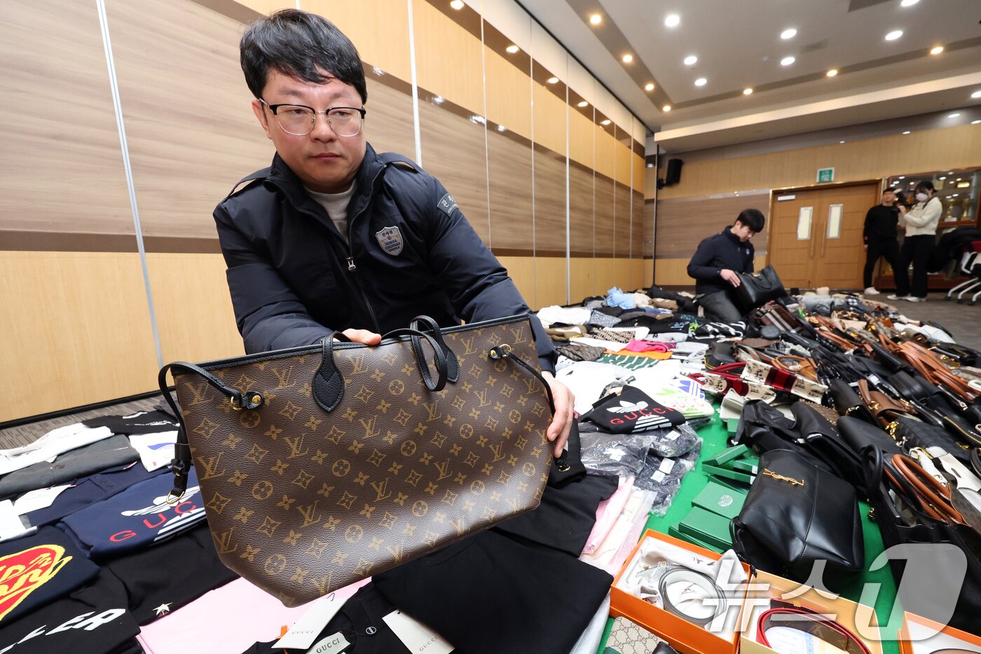본문 이미지 - 27일 오전 인천 중구 인천본부세관에서 열린 '1200억원대 위조 명품 판매 쇼핑몰 운영조직 적발' 브리핑에서 직원들이 압수품을 살펴보고 있다.  2026.1.27/뉴스1 ⓒ News1 황기선 기자