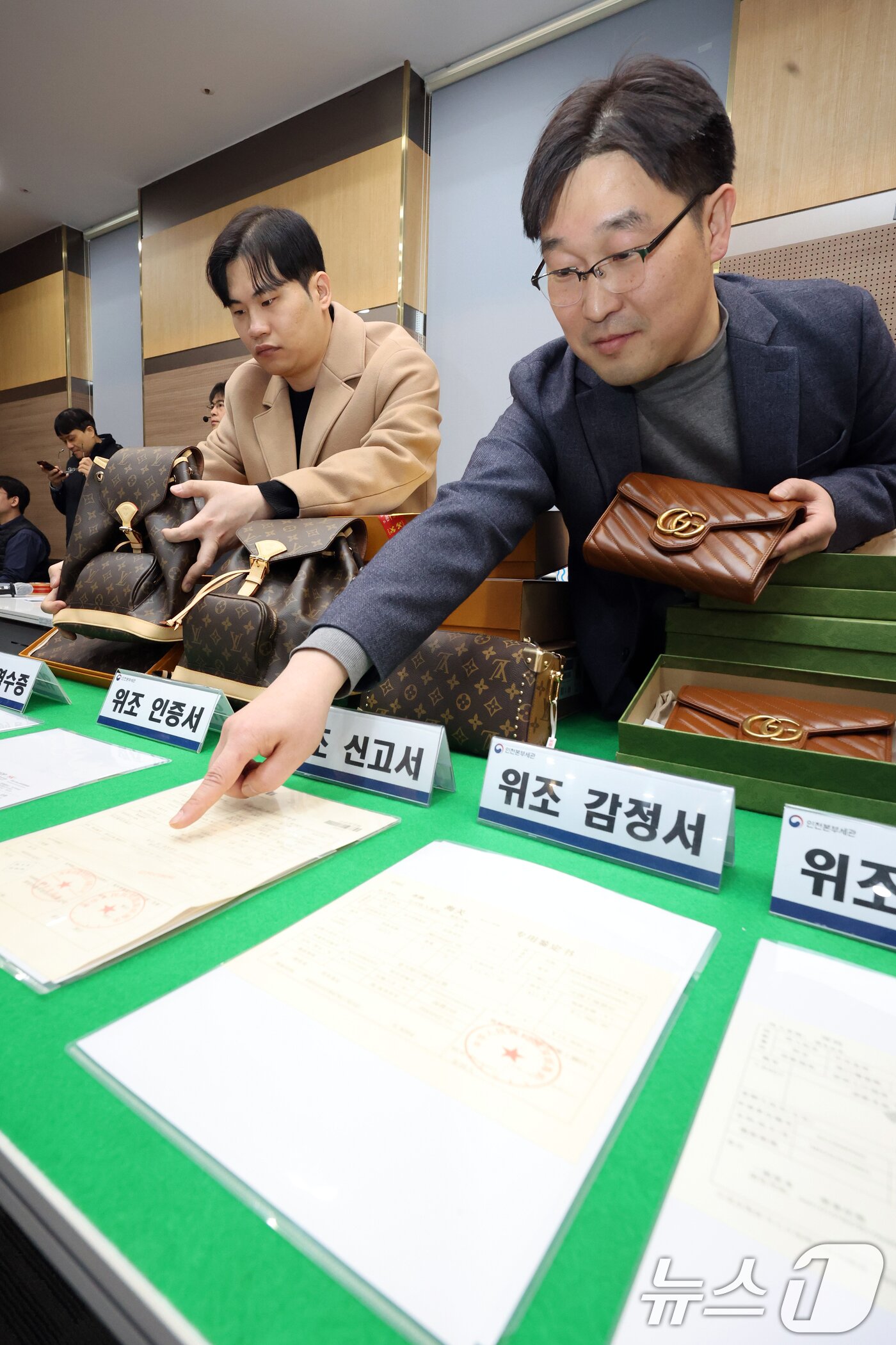 본문 이미지 - 27일 오전 인천 중구 인천본부세관에서 열린 '1200억원대 위조 명품 판매 쇼핑몰 운영조직 적발' 브리핑에서 직원들이 압수품을 살펴보고 있다. 2026.1.27/뉴스1 ⓒ News1 황기선 기자