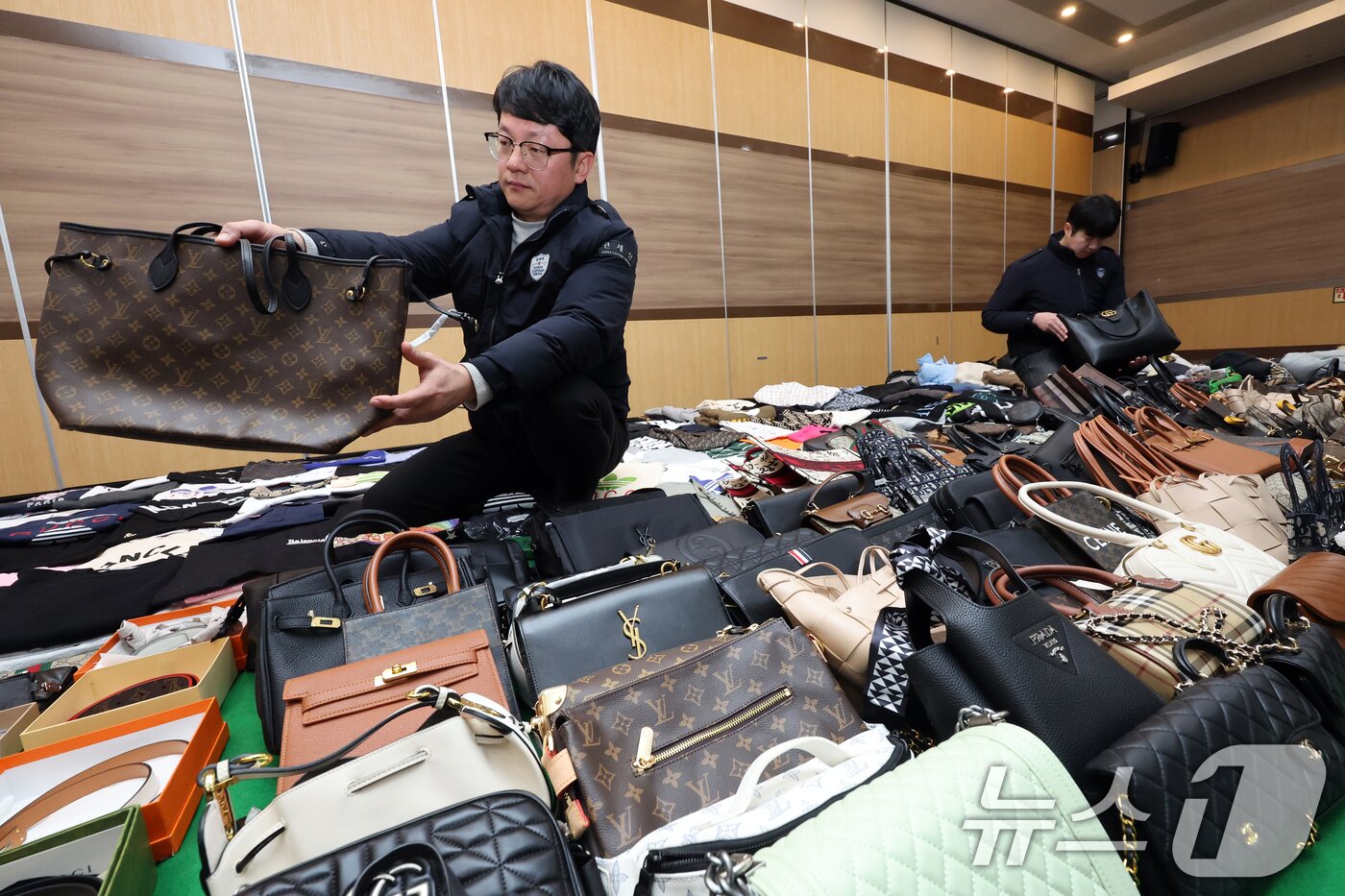 본문 이미지 - 27일 오전 인천 중구 인천본부세관에서 열린 '1200억원대 위조 명품 판매 쇼핑몰 운영조직 적발' 브리핑에서 직원들이 압수품을 살펴보고 있다. 2026.1.27/뉴스1 ⓒ News1 황기선 기자