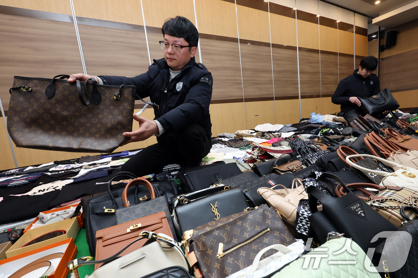 (인천=뉴스1) 황기선 기자 = 27일 오전 인천 중구 인천본부세관에서 열린 '1200억원대 위조 명품 판매 쇼핑몰 운영조직 적발' 브리핑에서 직원들이 압수품을 살펴보고 있다. 관 …