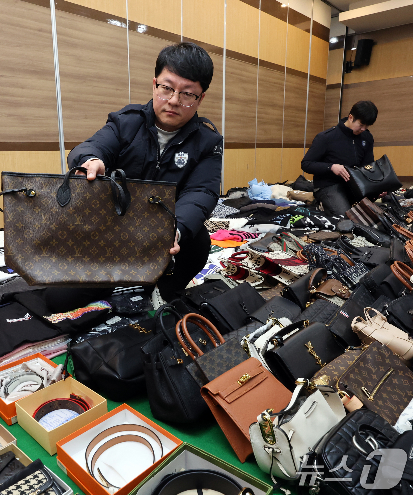 (인천=뉴스1) 황기선 기자 = 27일 오전 인천 중구 인천본부세관에서 열린 '1200억원대 위조 명품 판매 쇼핑몰 운영조직 적발' 브리핑에서 직원들이 압수품을 살펴보고 있다.관세 …