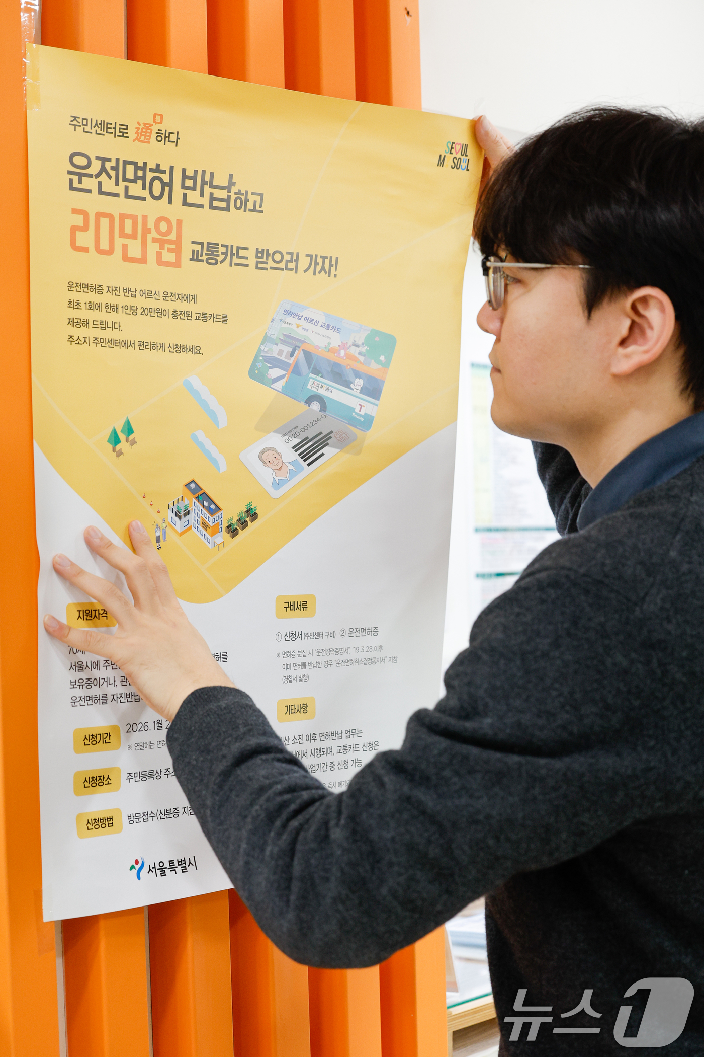 (서울=뉴스1) 안은나 기자 = 고령 운전자의 교통사고 예방을 위한 운전면허 자진 반납 신청을 하루 앞둔 27일 서울 송파구 석촌동주민센터에서 직원이 안내문을 부착하고 있다.서울시 …