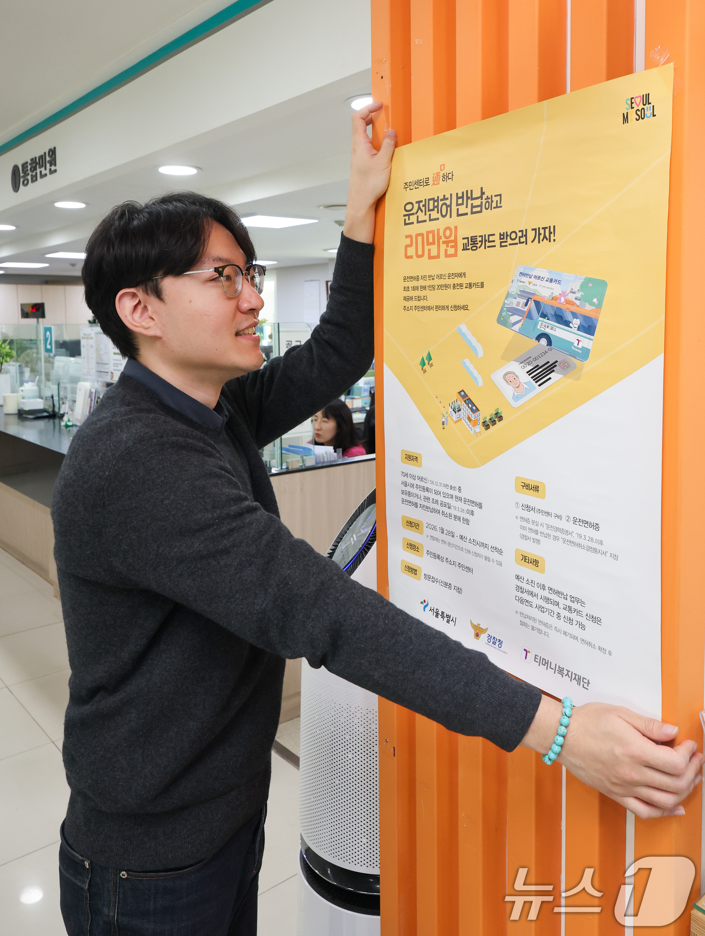 (서울=뉴스1) 안은나 기자 = 고령 운전자의 교통사고 예방을 위한 운전면허 자진 반납 신청을 하루 앞둔 27일 서울 송파구 석촌동주민센터에서 직원이 안내문을 부착하고 있다.서울시 …