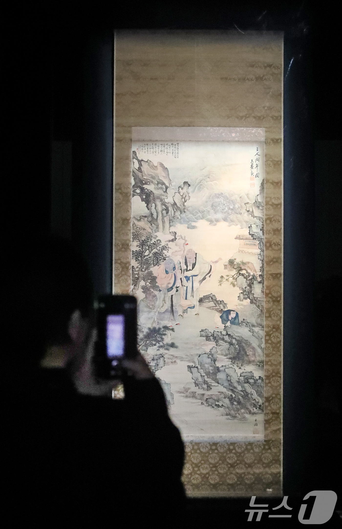 (대구=뉴스1) 공정식 기자 = 27일 오전 대구 수성구 대구간송미술관을 찾은 관람객이 오원 장승업의 '삼인문년(三人問年)'을 감상하고 있다.대구간송미술관은 병오년 새해를 맞아 상 …