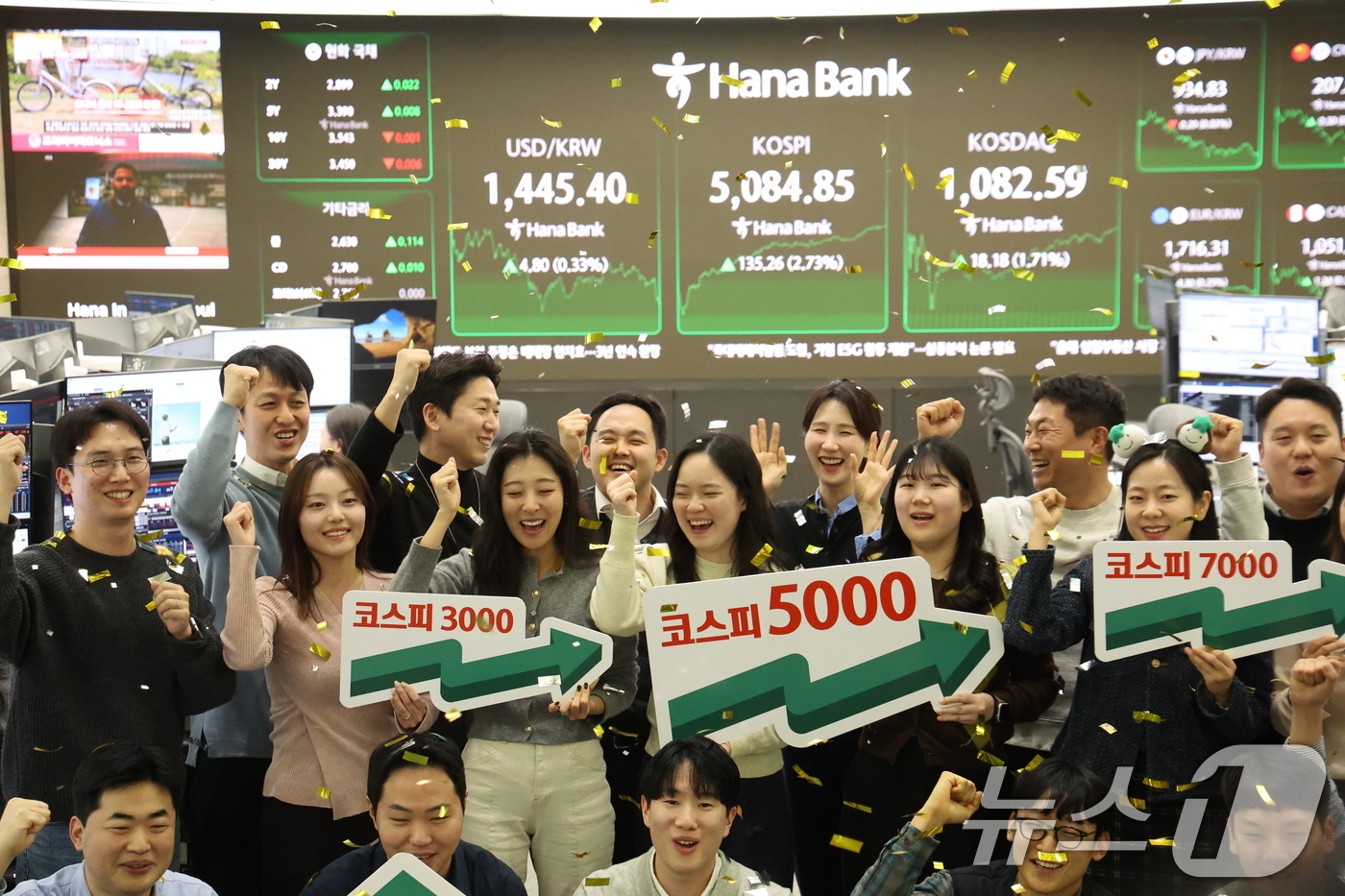 (서울=뉴스1) 황기선 기자 = 코스피가 종가 기준 사상 처음 5000선을 돌파한 27일 오후 서울 중구 하나은행 본점 딜링룸에서 직원들이 축하 세리머니를 하고 있다.이날 코스피지 …