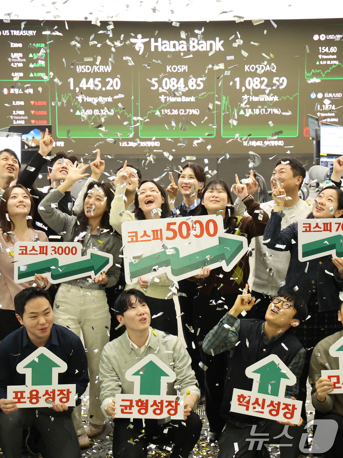 (서울=뉴스1) 황기선 기자 = 코스피가 종가 기준 사상 처음 5000선을 돌파한 27일 오후 서울 중구 하나은행 본점 딜링룸에서 직원들이 축하 세리머니를 하고 있다. 이날 코스피 …