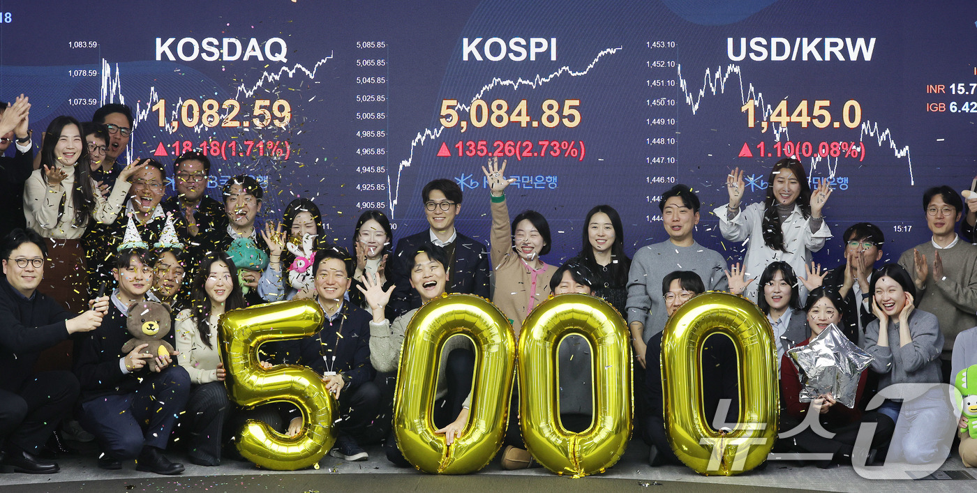 (서울=뉴스1) 박지혜 기자 = 코스피가 종가 기준 사상 처음 5000선을 돌파한 27일 오후 서울 영등포구 KB국민은행 딜링룸에서 직원들이 축하 세리머니를 하고 있다.이날 코스피 …