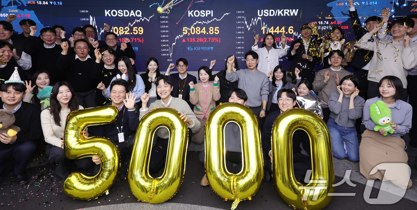 (서울=뉴스1) 박지혜 기자 = 코스피가 종가 기준 사상 처음 5000선을 돌파한 27일 오후 서울 영등포구 KB국민은행 딜링룸에서 직원들이 축하 세리머니를 하고 있다.이날 코스피 …