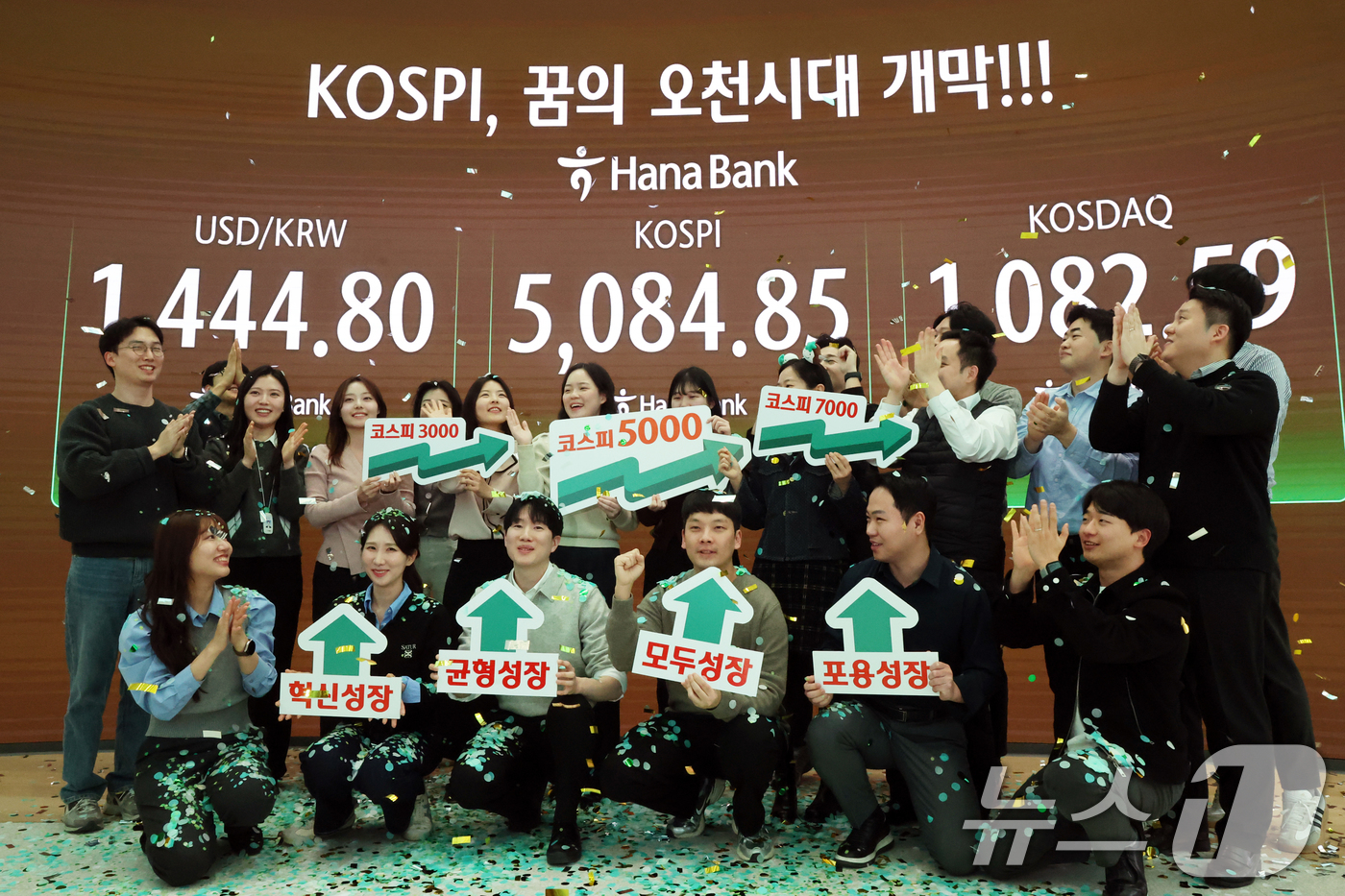 (서울=뉴스1) 황기선 기자 = 코스피가 종가 기준 사상 처음 5000선을 돌파한 27일 오후 서울 중구 하나은행 본점 딜링룸에서 직원들이 축하 세리머니를 하고 있다.이날 코스피지 …