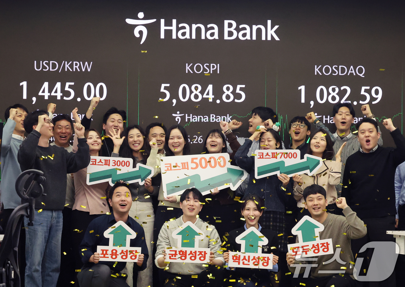 (서울=뉴스1) 황기선 기자 = 코스피가 종가 기준 사상 처음 5000선을 돌파한 27일 오후 서울 중구 하나은행 본점 딜링룸에서 직원들이 축하 세리머니를 하고 있다.이날 코스피지 …