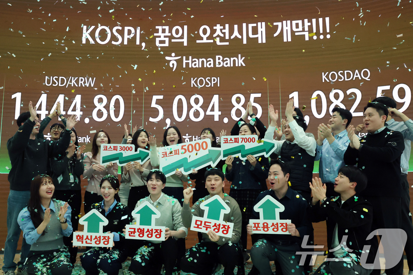 (서울=뉴스1) 황기선 기자 = 코스피가 종가 기준 사상 처음 5000선을 돌파한 27일 오후 서울 중구 하나은행 본점 딜링룸에서 직원들이 축하 세리머니를 하고 있다.이날 코스피지 …