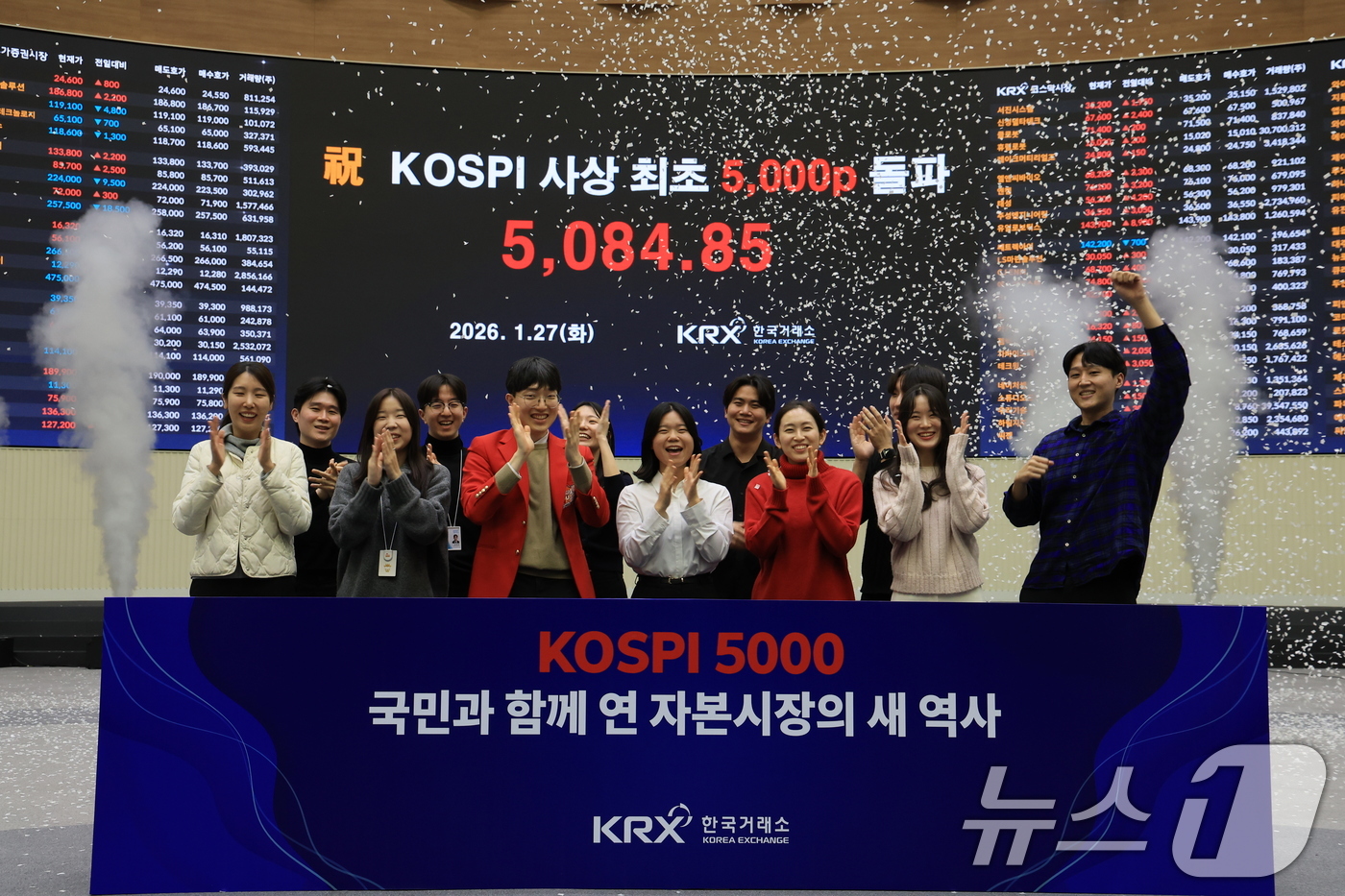 (서울=뉴스1) 이호윤 기자 = 한국 증시 최초로 종가 기준 코스피 5000을 달성한 27일 서울 영등포구 한국거래소에서 직원들이 코스피 종가가 표시된 전광판을 배경으로 세레머니를 …