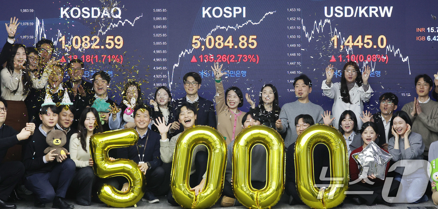 (서울=뉴스1) 박지혜 기자 = 코스피가 종가 기준 사상 처음 5000선을 돌파한 27일 오후 서울 영등포구 KB국민은행 딜링룸에서 직원들이 축하 세리머니를 하고 있다.이날 코스피 …