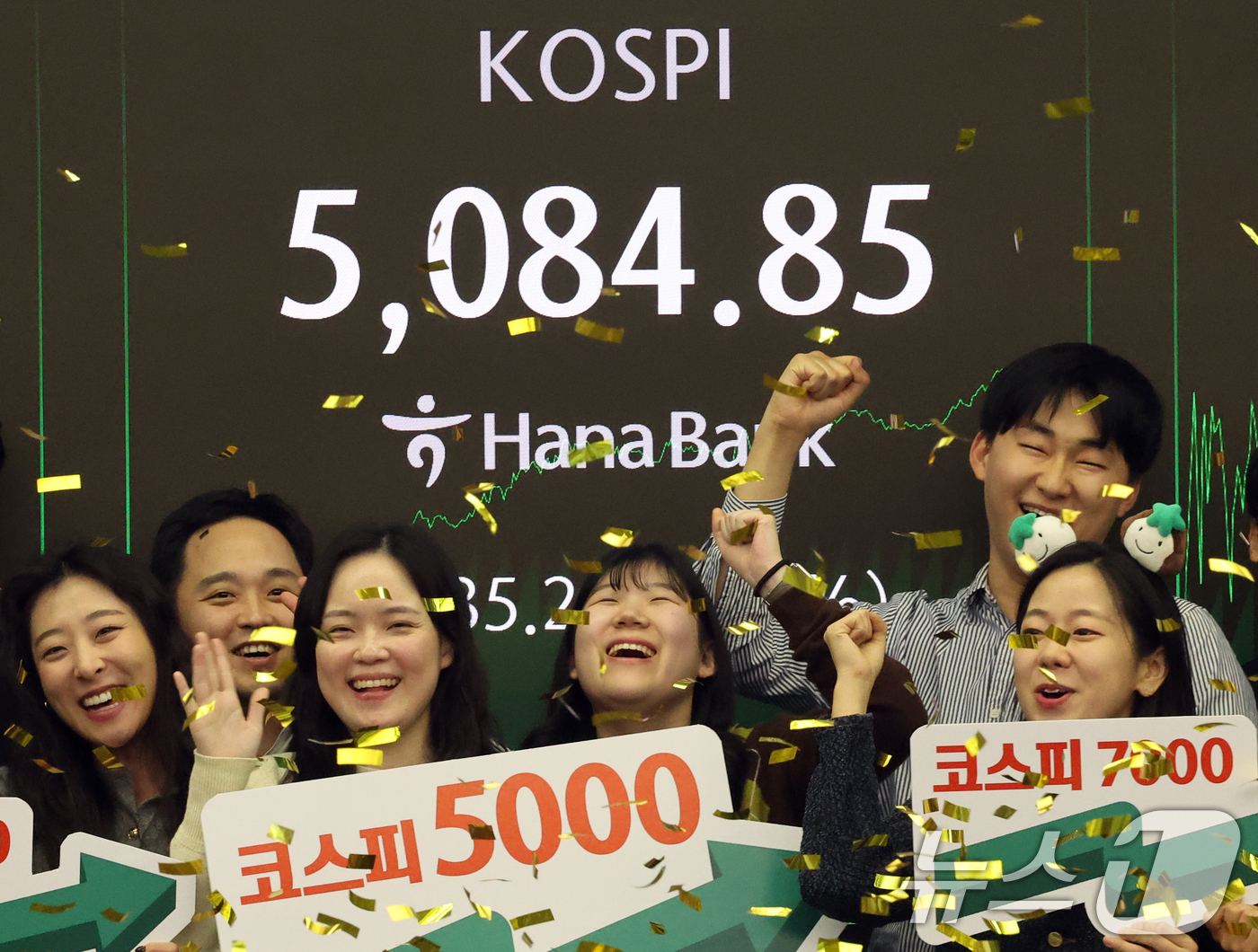 (서울=뉴스1) 황기선 기자 = 코스피가 종가 기준 사상 처음 5000선을 돌파한 27일 오후 서울 중구 하나은행 본점 딜링룸에서 직원들이 축하 세리머니를 하고 있다.이날 코스피지 …