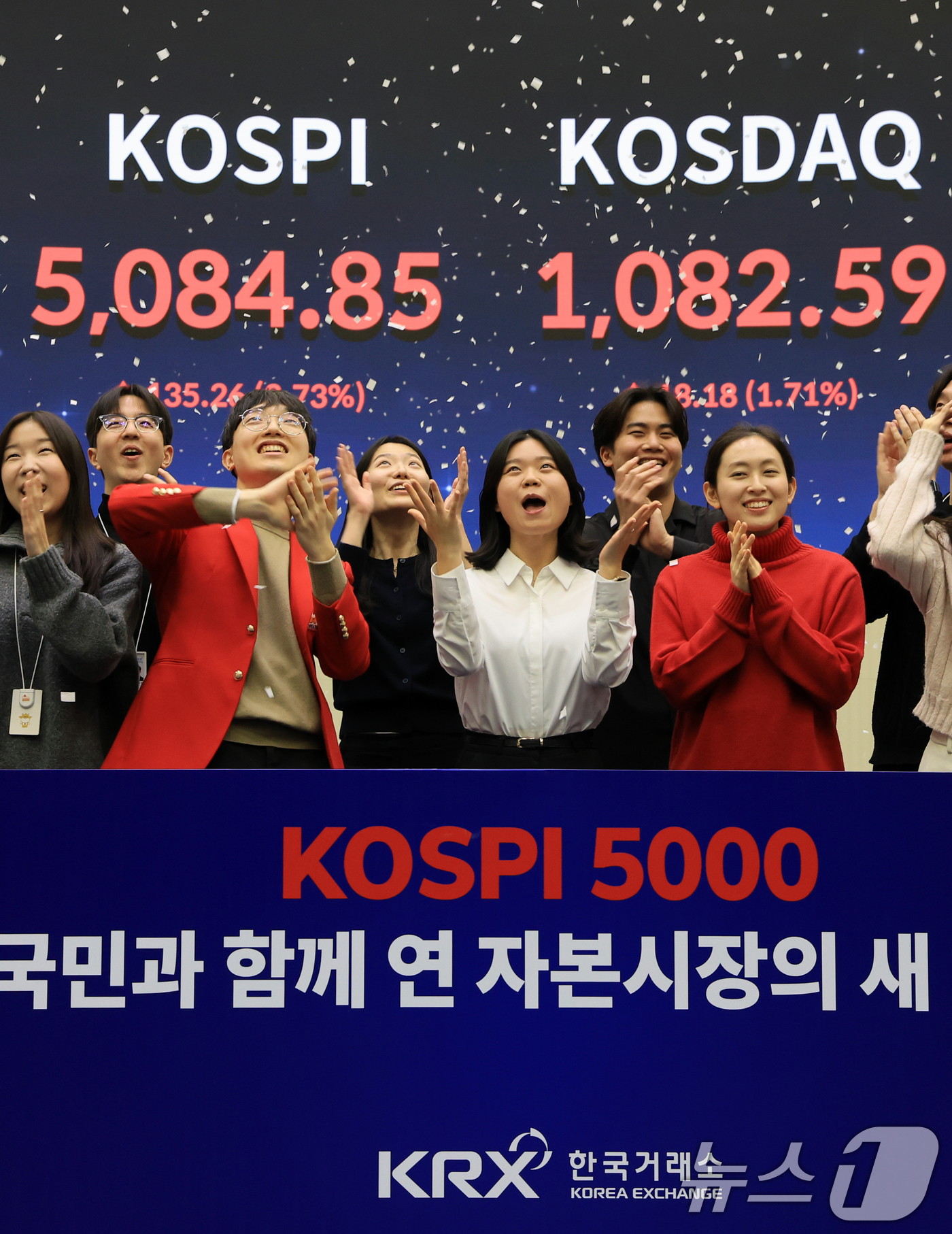 (서울=뉴스1) 이호윤 기자 = 한국 증시 최초로 종가 기준 코스피 5000을 달성한 27일 서울 영등포구 한국거래소에서 직원들이 코스피 종가가 표시된 전광판을 배경으로 세레머니를 …