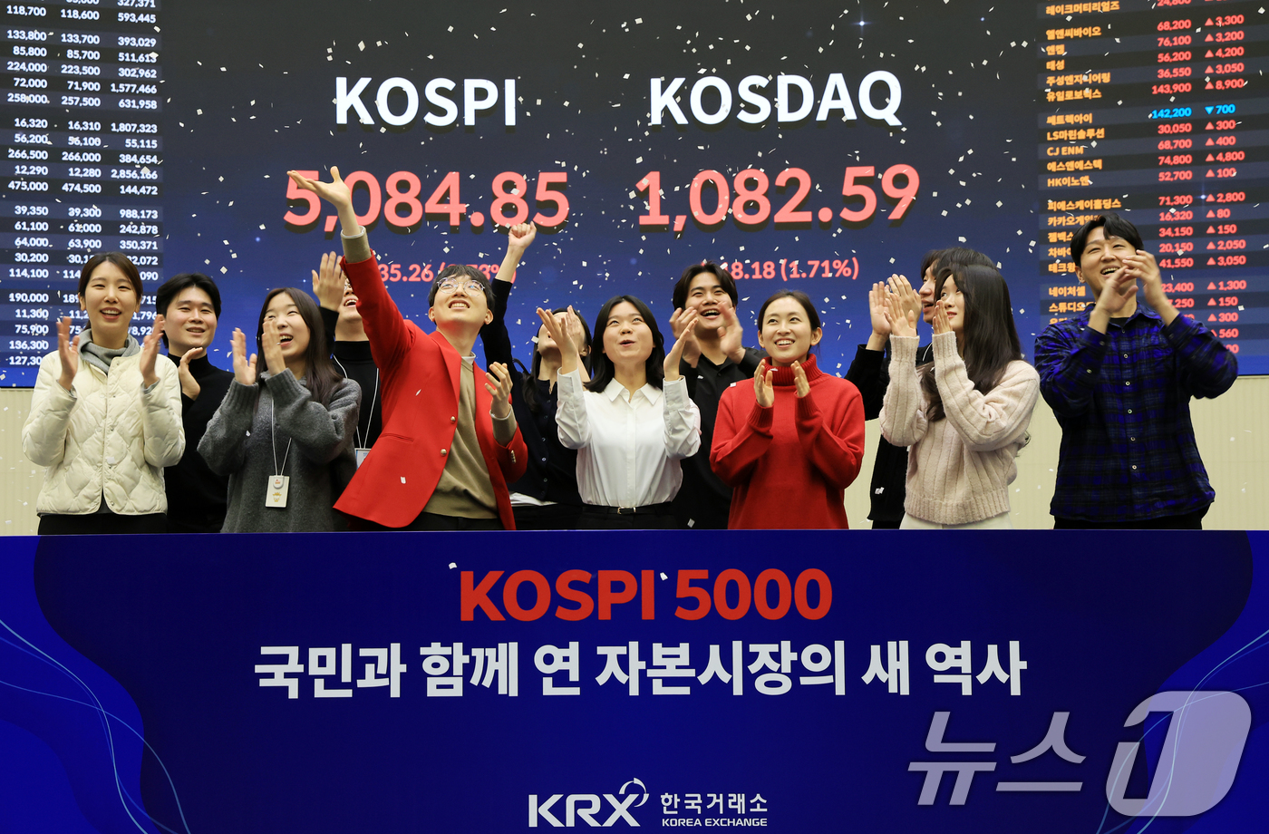 (서울=뉴스1) 이호윤 기자 = 한국 증시 최초로 종가 기준 코스피 5000을 달성한 27일 서울 영등포구 한국거래소에서 직원들이 코스피 종가가 표시된 전광판을 배경으로 세레머니를 …
