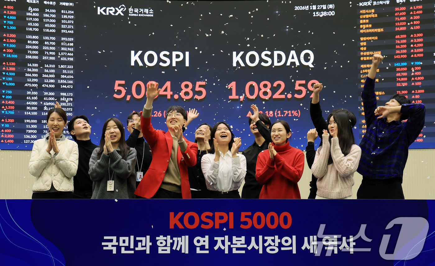 (서울=뉴스1) 이호윤 기자 = 한국 증시 최초로 종가 기준 코스피 5000을 달성한 27일 서울 영등포구 한국거래소에서 직원들이 코스피 종가가 표시된 전광판을 배경으로 세레머니를 …