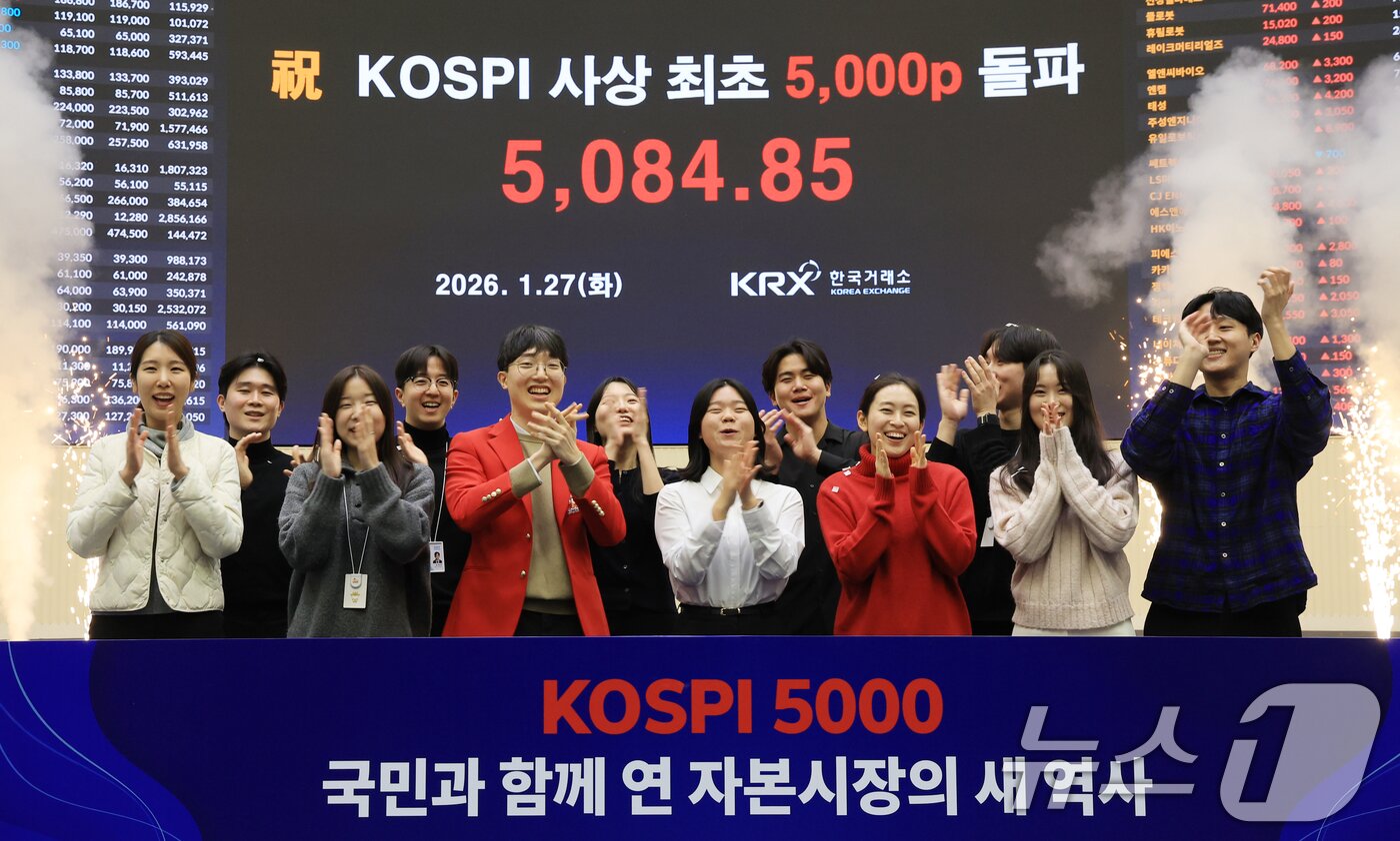본문 이미지 - 한국 증시 최초로 종가 기준 코스피 5000을 달성한 27일 서울 영등포구 한국거래소에서 직원들이 코스피 종가가 표시된 전광판을 배경으로 세레머니를 하고 있다.  2026.1.27/뉴스1 ⓒ News1 이호윤 기자