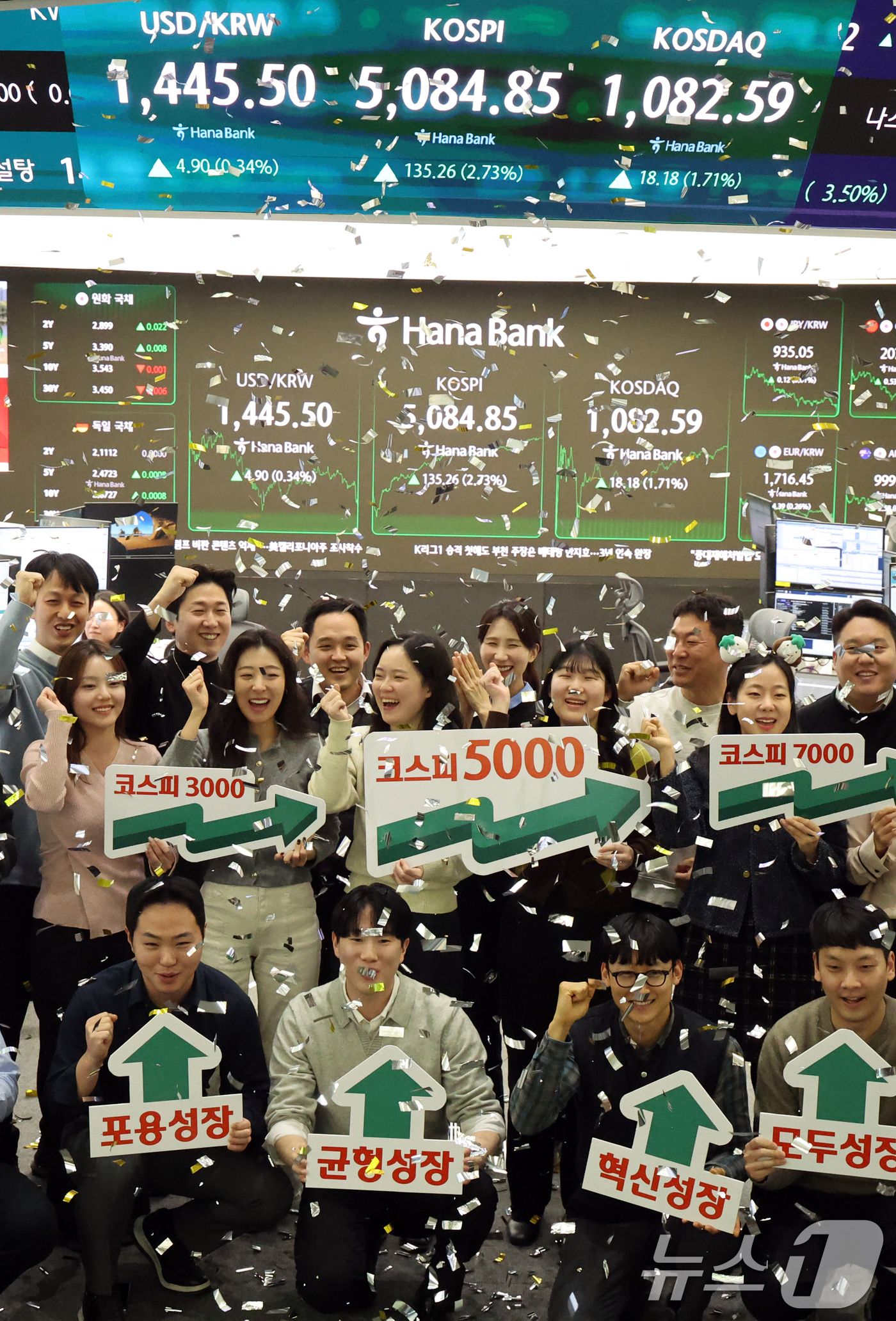 (서울=뉴스1) 황기선 기자 = 코스피가 종가 기준 사상 처음 5000선을 돌파한 27일 오후 서울 중구 하나은행 본점 딜링룸에서 직원들이 축하 세리머니를 하고 있다.이날 코스피지 …