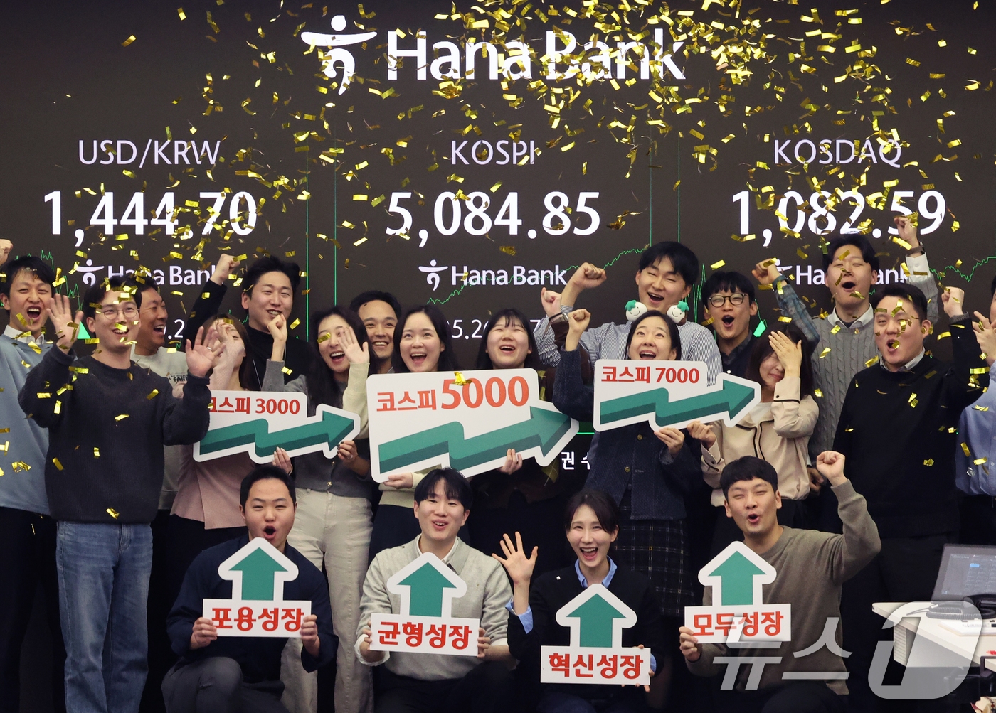 (서울=뉴스1) 황기선 기자 = 코스피가 종가 기준 사상 처음 5000선을 돌파한 27일 오후 서울 중구 하나은행 본점 딜링룸에서 직원들이 축하 세리머니를 하고 있다.이날 코스피지 …