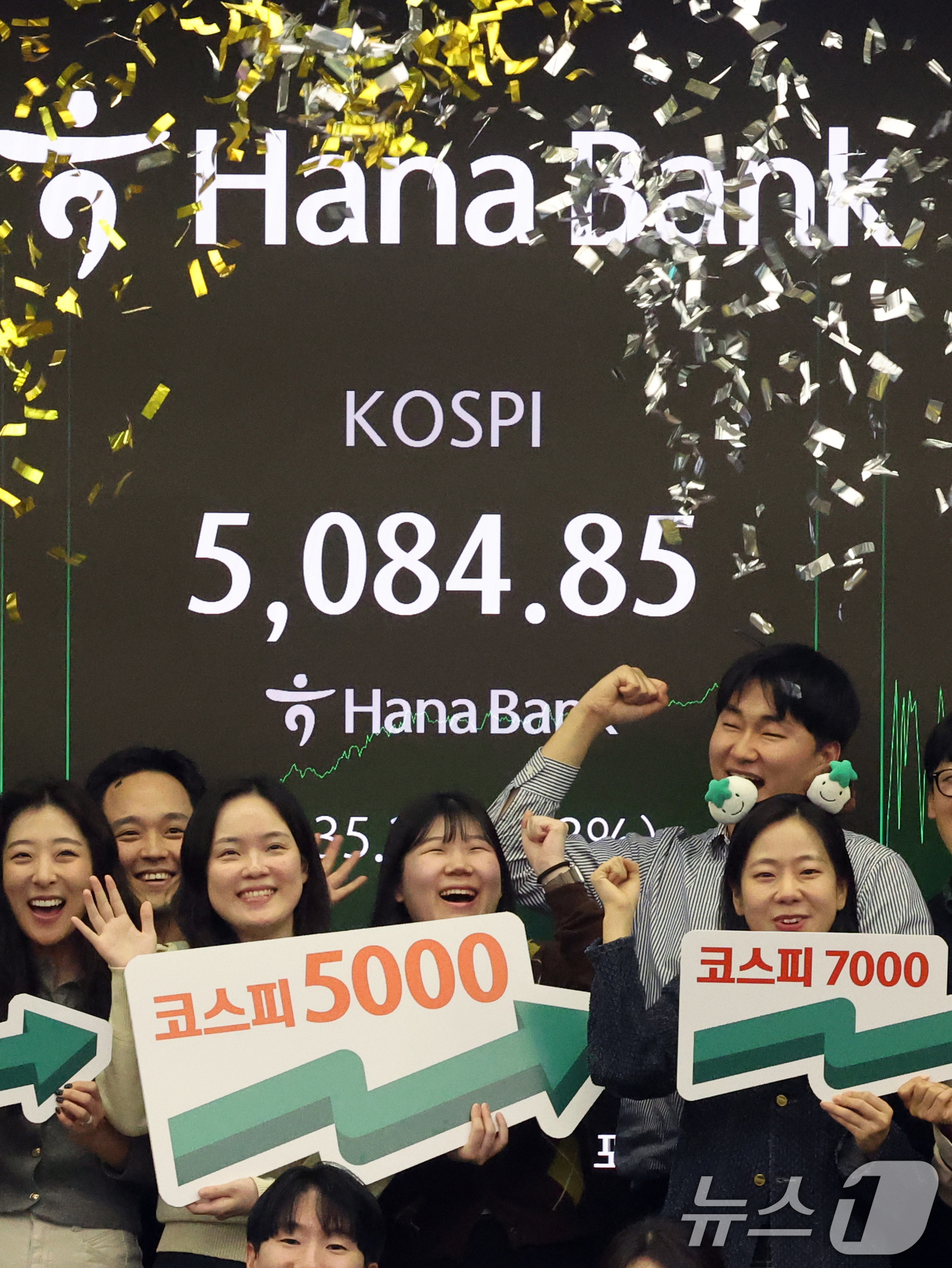 (서울=뉴스1) 황기선 기자 = 코스피가 종가 기준 사상 처음 5000선을 돌파한 27일 오후 서울 중구 하나은행 본점 딜링룸에서 직원들이 축하 세리머니를 하고 있다.이날 코스피지 …