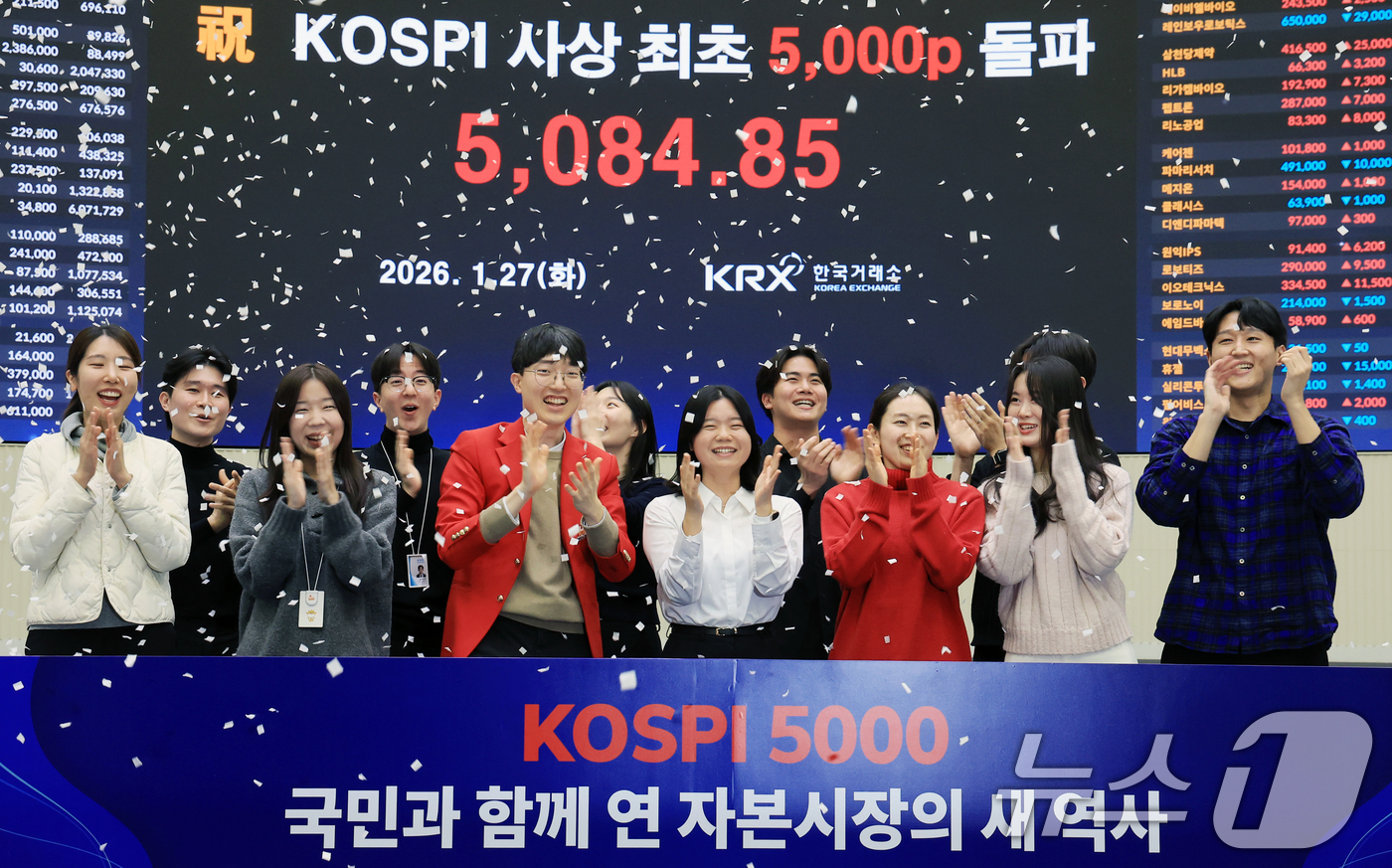 (서울=뉴스1) 이호윤 기자 = 한국 증시 최초로 종가 기준 코스피 5000을 달성한 27일 서울 영등포구 한국거래소에서 직원들이 코스피 종가가 표시된 전광판을 배경으로 세레머니를 …