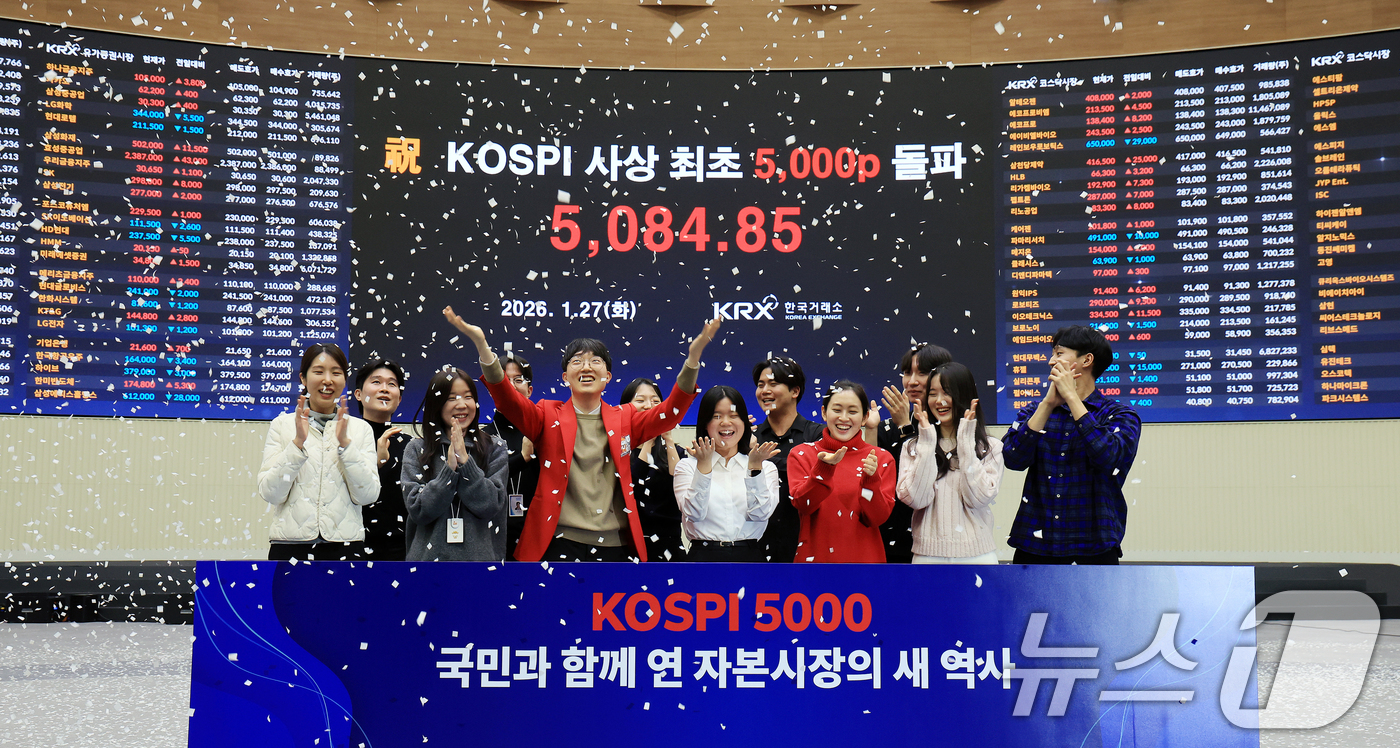 (서울=뉴스1) 이호윤 기자 = 한국 증시 최초로 종가 기준 코스피 5000을 달성한 27일 서울 영등포구 한국거래소에서 직원들이 코스피 종가가 표시된 전광판을 배경으로 세레머니를 …