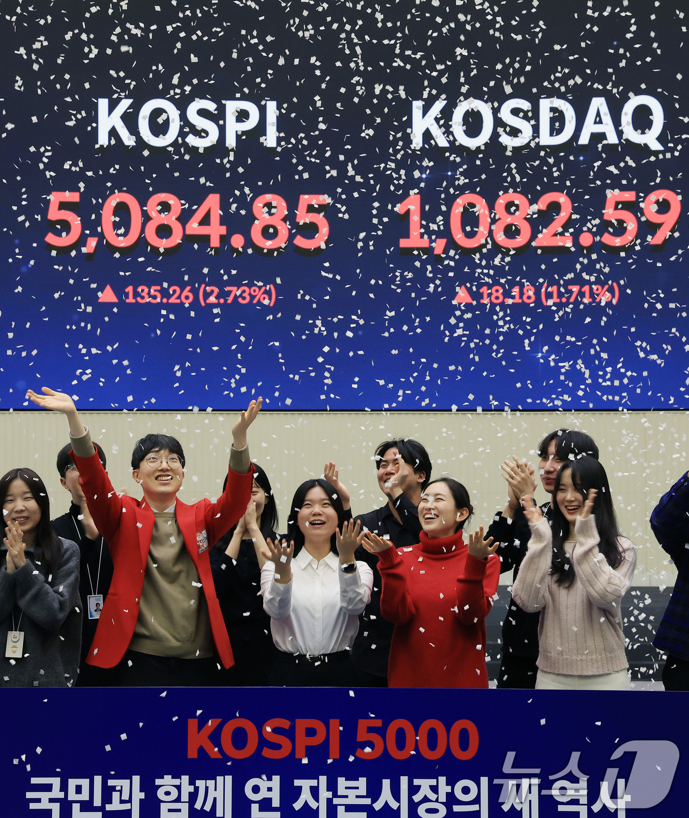 (서울=뉴스1) 이호윤 기자 = 한국 증시 최초로 종가 기준 코스피 5000을 달성한 27일 서울 영등포구 한국거래소에서 직원들이 코스피 종가가 표시된 전광판을 배경으로 세레머니를 …