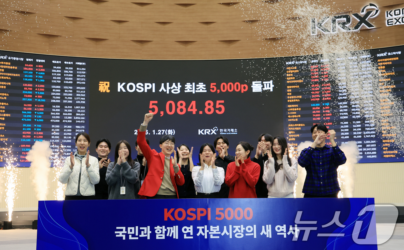 (서울=뉴스1) 이호윤 기자 = 한국 증시 최초로 종가 기준 코스피 5000을 달성한 27일 서울 영등포구 한국거래소에서 직원들이 코스피 종가가 표시된 전광판을 배경으로 세레머니를 …