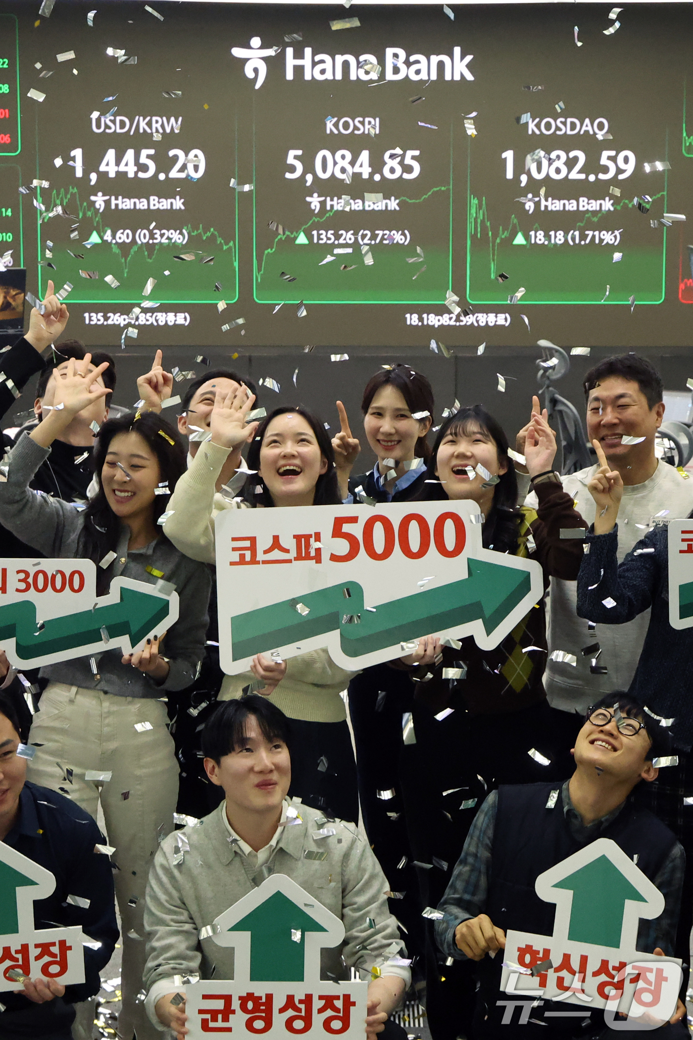 (서울=뉴스1) 황기선 기자 = 코스피가 종가 기준 사상 처음 5000선을 돌파한 27일 오후 서울 중구 하나은행 본점 딜링룸에서 직원들이 축하 세리머니를 하고 있다.이날 코스피지 …