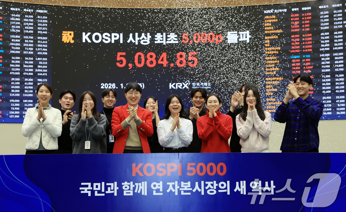 (서울=뉴스1) 이호윤 기자 = 한국 증시 최초로 종가 기준 코스피 5000을 달성한 27일 서울 영등포구 한국거래소에서 직원들이 코스피 종가가 표시된 전광판을 배경으로 세레머니를 …