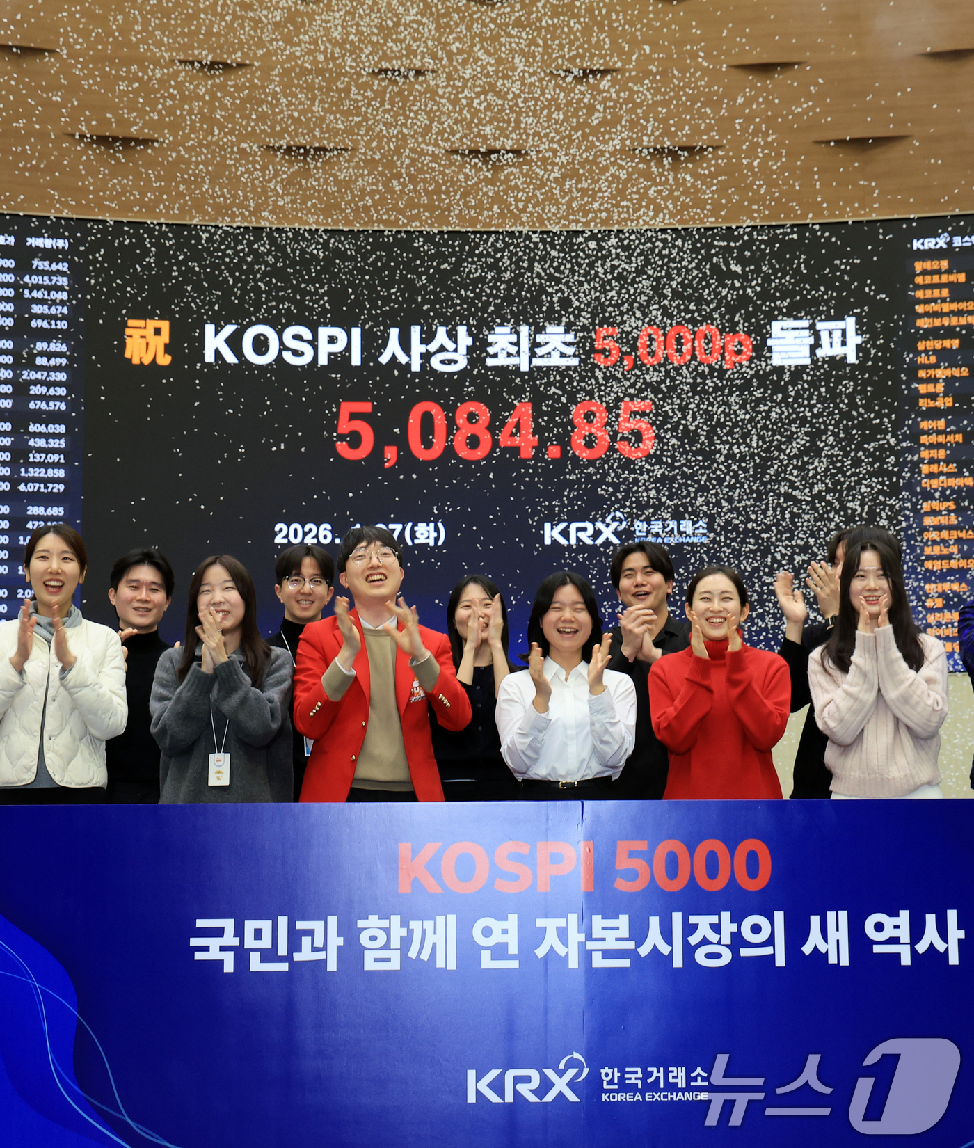 (서울=뉴스1) 이호윤 기자 = 한국 증시 최초로 종가 기준 코스피 5000을 달성한 27일 서울 영등포구 한국거래소에서 직원들이 코스피 종가가 표시된 전광판을 배경으로 세레머니를 …