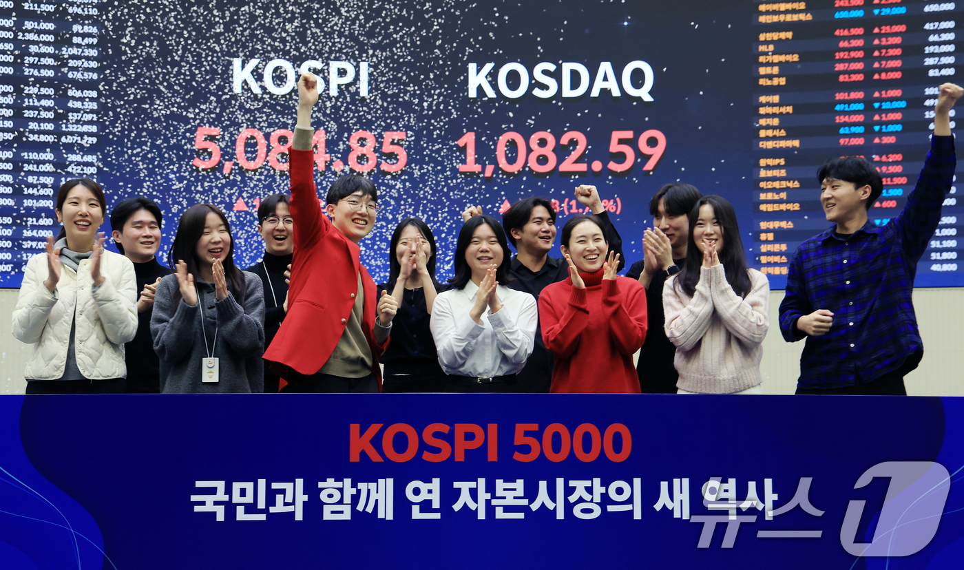 (서울=뉴스1) 이호윤 기자 = 한국 증시 최초로 종가 기준 코스피 5000을 달성한 27일 서울 영등포구 한국거래소에서 직원들이 코스피 종가가 표시된 전광판을 배경으로 세레머니를 …