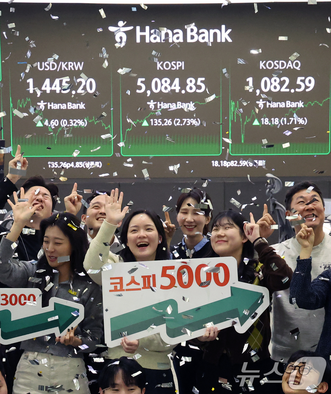 (서울=뉴스1) 황기선 기자 = 코스피가 종가 기준 사상 처음 5000선을 돌파한 27일 오후 서울 중구 하나은행 본점 딜링룸에서 직원들이 축하 세리머니를 하고 있다.이날 코스피지 …