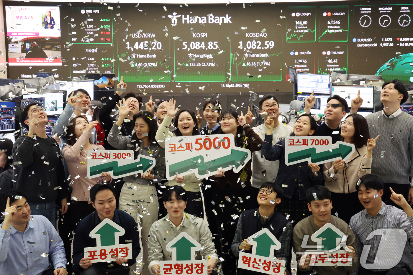 (서울=뉴스1) 황기선 기자 = 코스피가 종가 기준 사상 처음 5000선을 돌파한 27일 오후 서울 중구 하나은행 본점 딜링룸에서 직원들이 축하 세리머니를 하고 있다.이날 코스피지 …