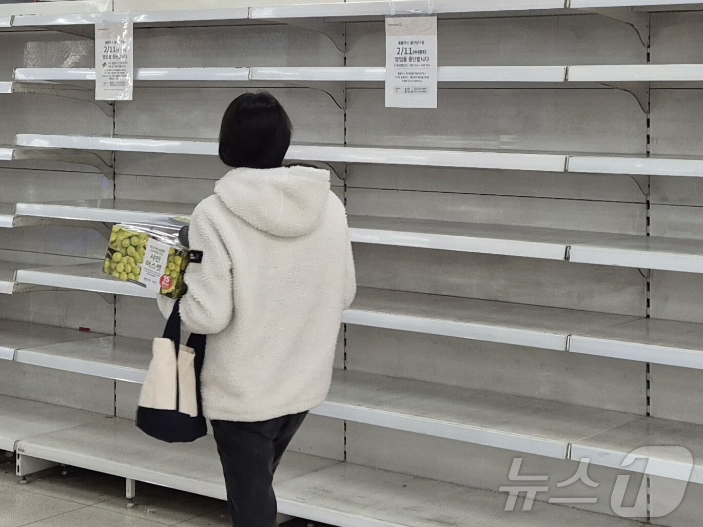 본문 이미지 - 한 시민이 홈플러스 울산남구점의 빈 매대 앞을 지나고 있다. 이 매대엔  '2월 11일부터 영업을 종료한다'는 안내문이 붙어 있다.2026.1.27/뉴스1ⓒ 뉴스1 박정현 기자 ⓒ News1 박정현 기자