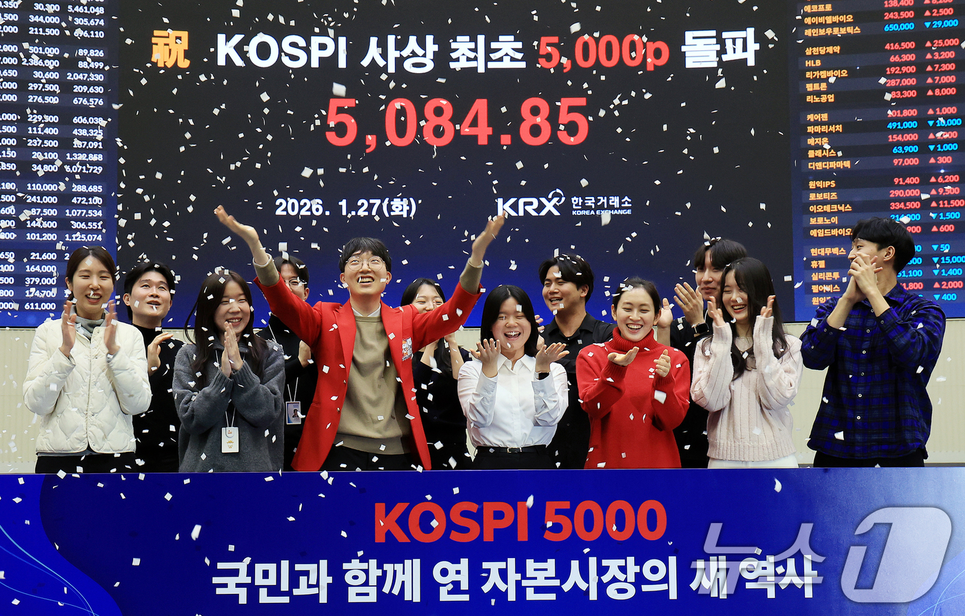 (서울=뉴스1) 이호윤 기자 = 한국 증시 최초로 종가 기준 코스피 5000을 달성한 27일 서울 영등포구 한국거래소에서 직원들이 코스피 종가가 표시된 전광판을 배경으로 세레머니를 …