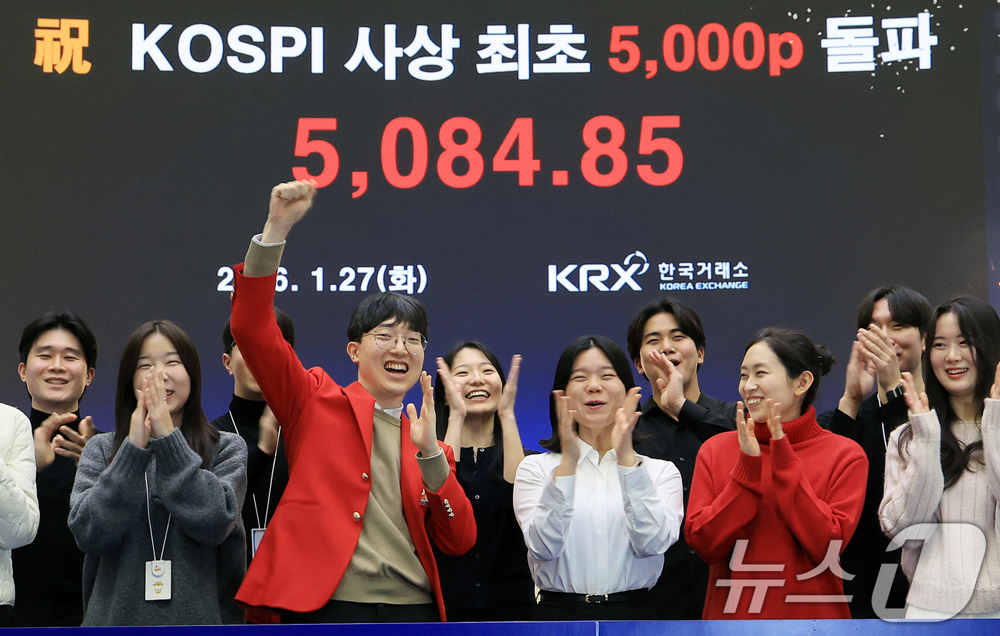 (서울=뉴스1) 이호윤 기자 = 한국 증시 최초로 종가 기준 코스피 5000을 달성한 27일 서울 영등포구 한국거래소에서 직원들이 코스피 종가가 표시된 전광판을 배경으로 세레머니를 …