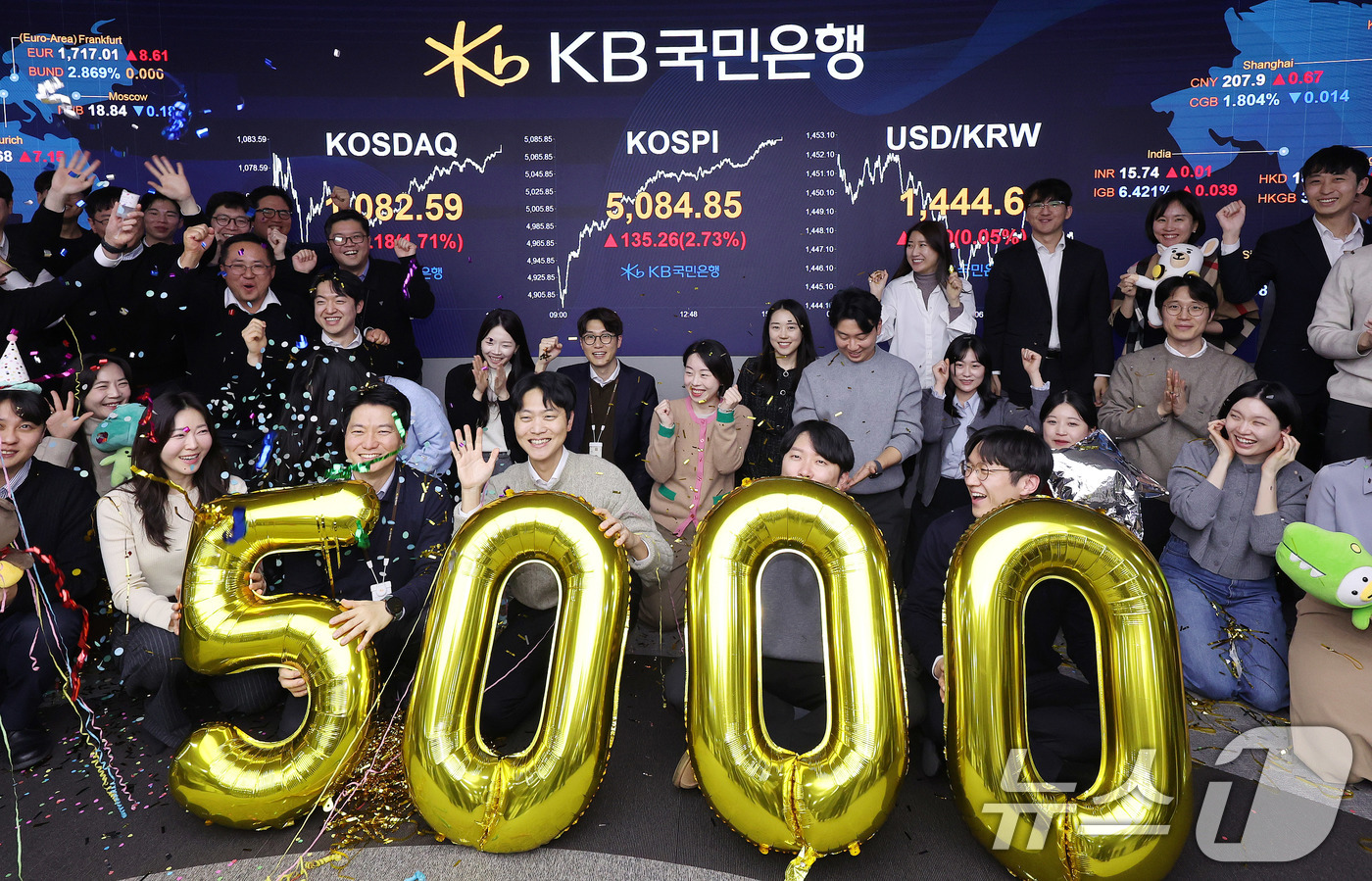 (서울=뉴스1) 박지혜 기자 = 코스피가 종가 기준 사상 처음 5000선을 돌파한 27일 오후 서울 영등포구 KB국민은행 딜링룸에서 직원들이 축하 세리머니를 하고 있다.이날 코스피 …