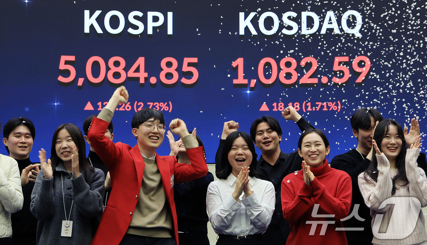 (서울=뉴스1) 이호윤 기자 = 한국 증시 최초로 종가 기준 코스피 5000을 달성한 27일 서울 영등포구 한국거래소에서 직원들이 코스피 종가가 표시된 전광판을 배경으로 세레머니를 …