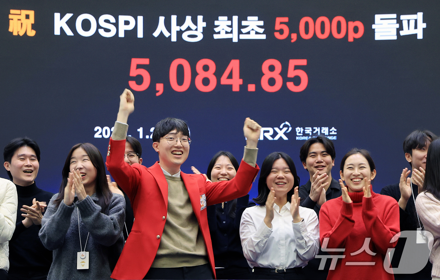 (서울=뉴스1) 이호윤 기자 = 한국 증시 최초로 종가 기준 코스피 5000을 달성한 27일 서울 영등포구 한국거래소에서 직원들이 코스피 종가가 표시된 전광판을 배경으로 세레머니를 …