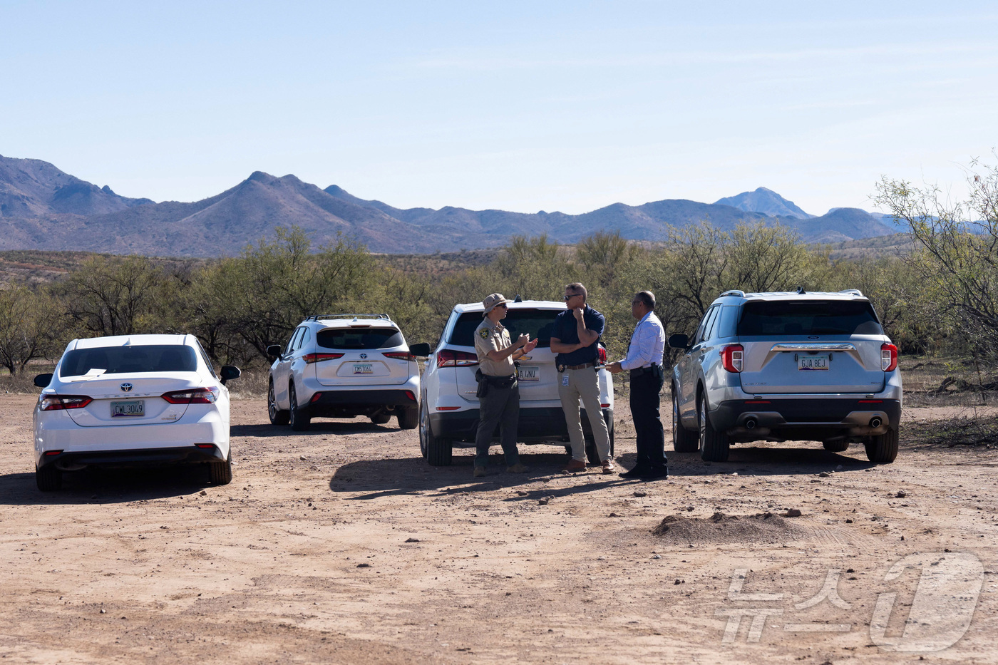 (로이터=뉴스1) 김경민 기자 = 법 집행 기관 요원들이 27일(현지시간) 미국 애리조나주 아리바카 인근 미국국경수비대가 연루된 총격 사건 현장에 모여 있다. 2026.1.27ⓒ …