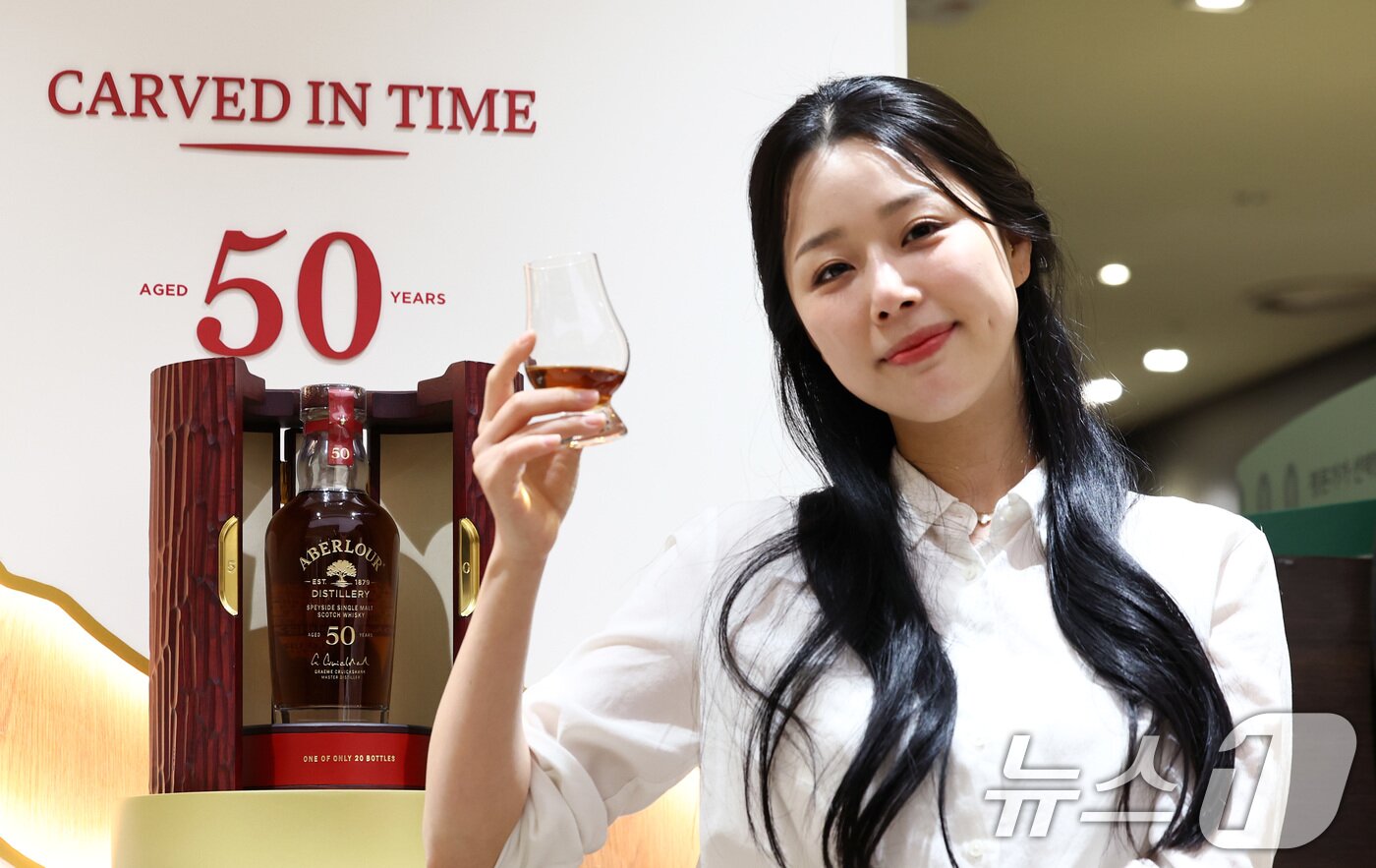 본문 이미지 - 28일 서울 중구 롯데백화점 본점 식품관에서 모델이 설 명절을 맞이해 전세계 단 20병 한정 생산된 '아벨라워 50년산'을 단독으로 선보이고 있다.  2026.1.28/뉴스1 ⓒ News1 최지환 기자