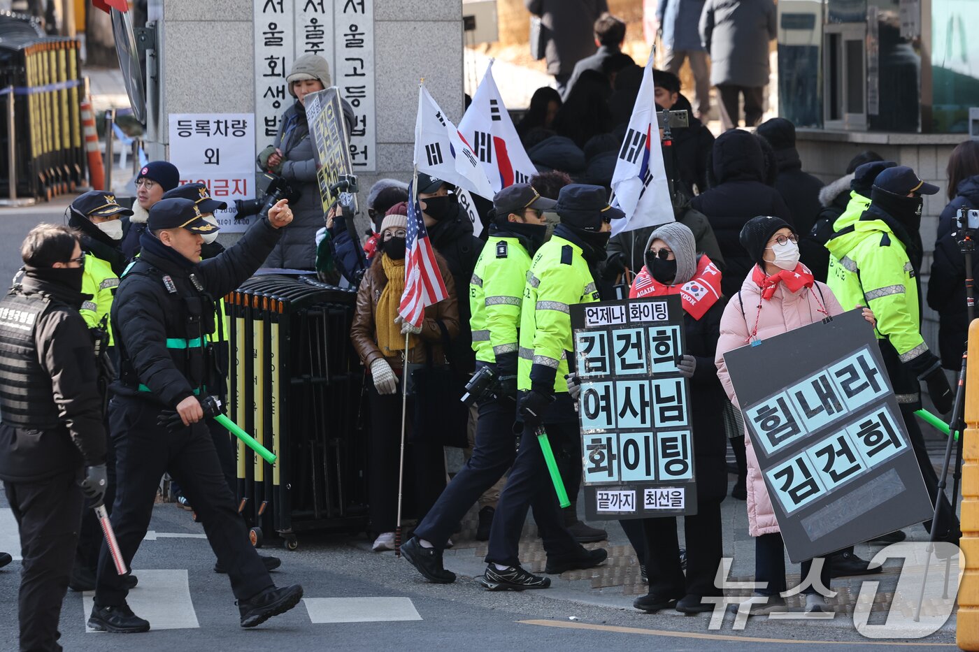 본문 이미지 - 김건희 여사의 자본시장과 금융투자업에 관한 법률 위반, 알선수재, 정치자금법 위반 등 혐의 1심 선고기일인 28일 오후 서울 서초구 중앙지방법원 앞에서 지지자들이 팻말과 태극기, 성조기를 들고 있다. 2026.1.28/뉴스1 ⓒ News1 안은나 기자