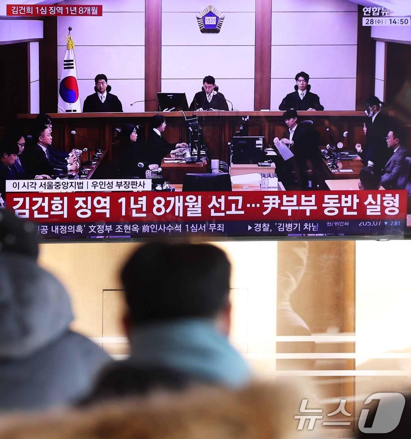 본문 이미지 - 28일 오후 서울역 대합실에서 시민들이 김건희 여사의 자본시장법·정치자금법 위반, 특정범죄 가중처벌법상 알선수재 혐의 1심 선고 공판 생중계를 지켜보고 있다. 서울중앙지법 형사합의27부(부장판사 우인성)는 이날 알선수재 등 혐의로 기소된 김 여사에게 징역 1년 8개월을 선고했다. 압수된 그라프사 다이아몬드 목걸이의 몰수 및 1281만 원의 추징도 명했다. 자본시장법 위반과 정치자금법 위반 혐의에 대해서는 무죄를 선고했다. 2026.1.28/뉴스1 ⓒ News1 오대일 기자