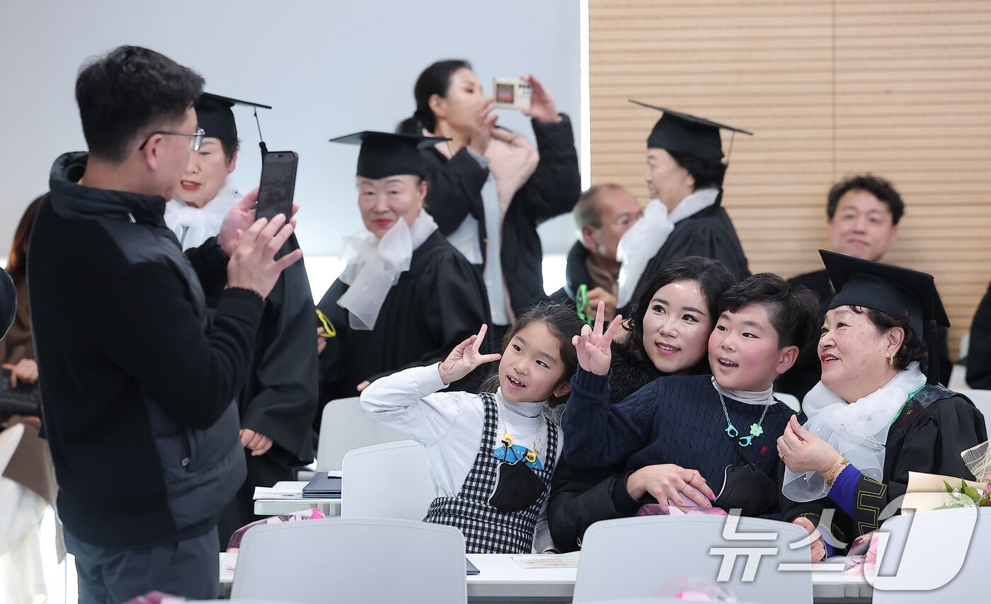 본문 이미지 - 28일 서울 영등포구 영등포구청에서 열린 2025학년도 영등포 늘푸름학교 졸업식에서 한 졸업생이 가족들과 기념촬영을 하고 있다. 2026.1.28/뉴스1 ⓒ News1 김성진 기자